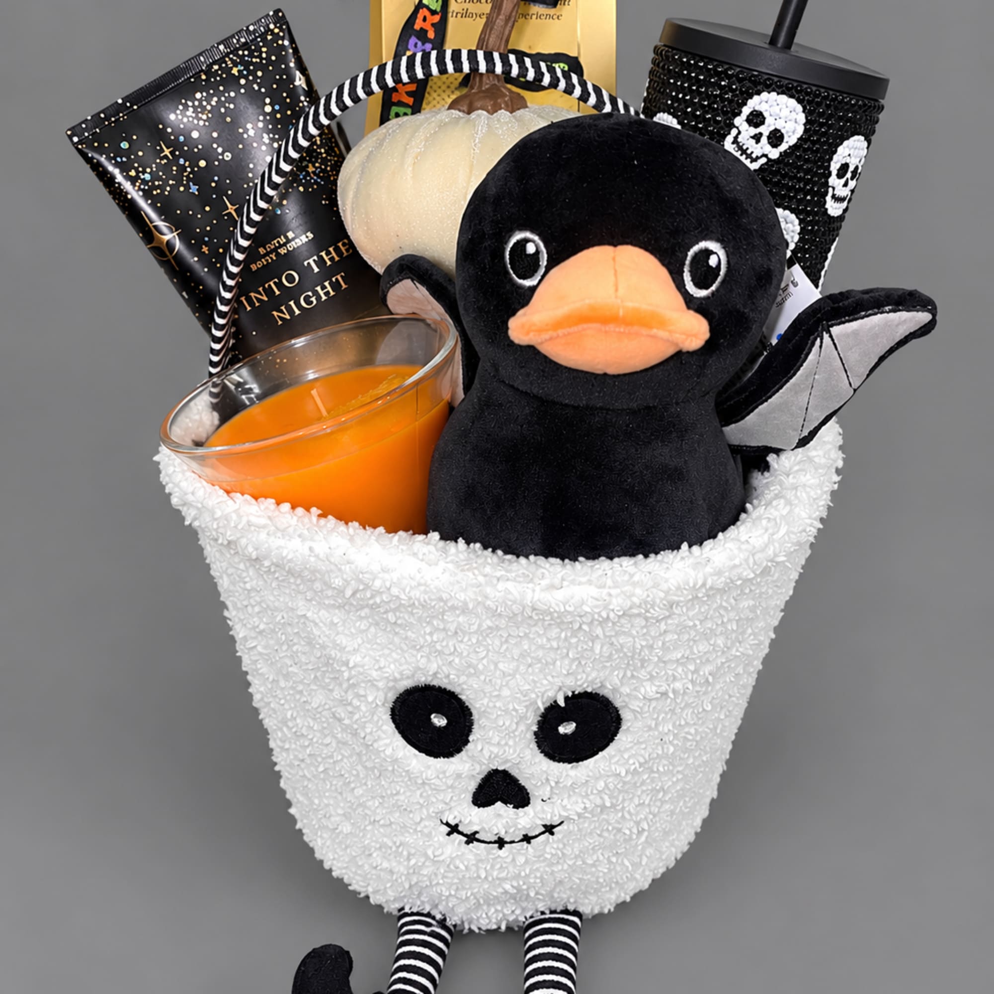Halloween gift basket with a plush duck, candle, candy, and spooky cup