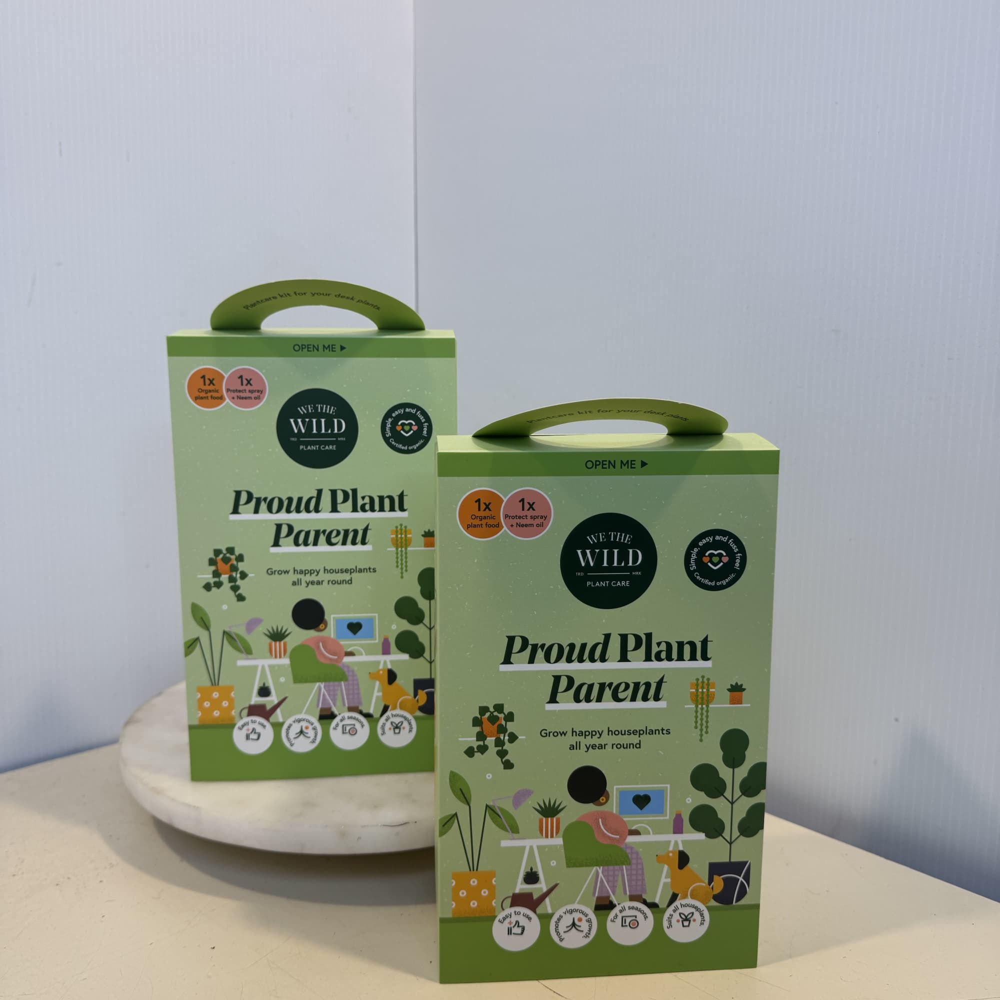Two green plant care gift boxes on a table
