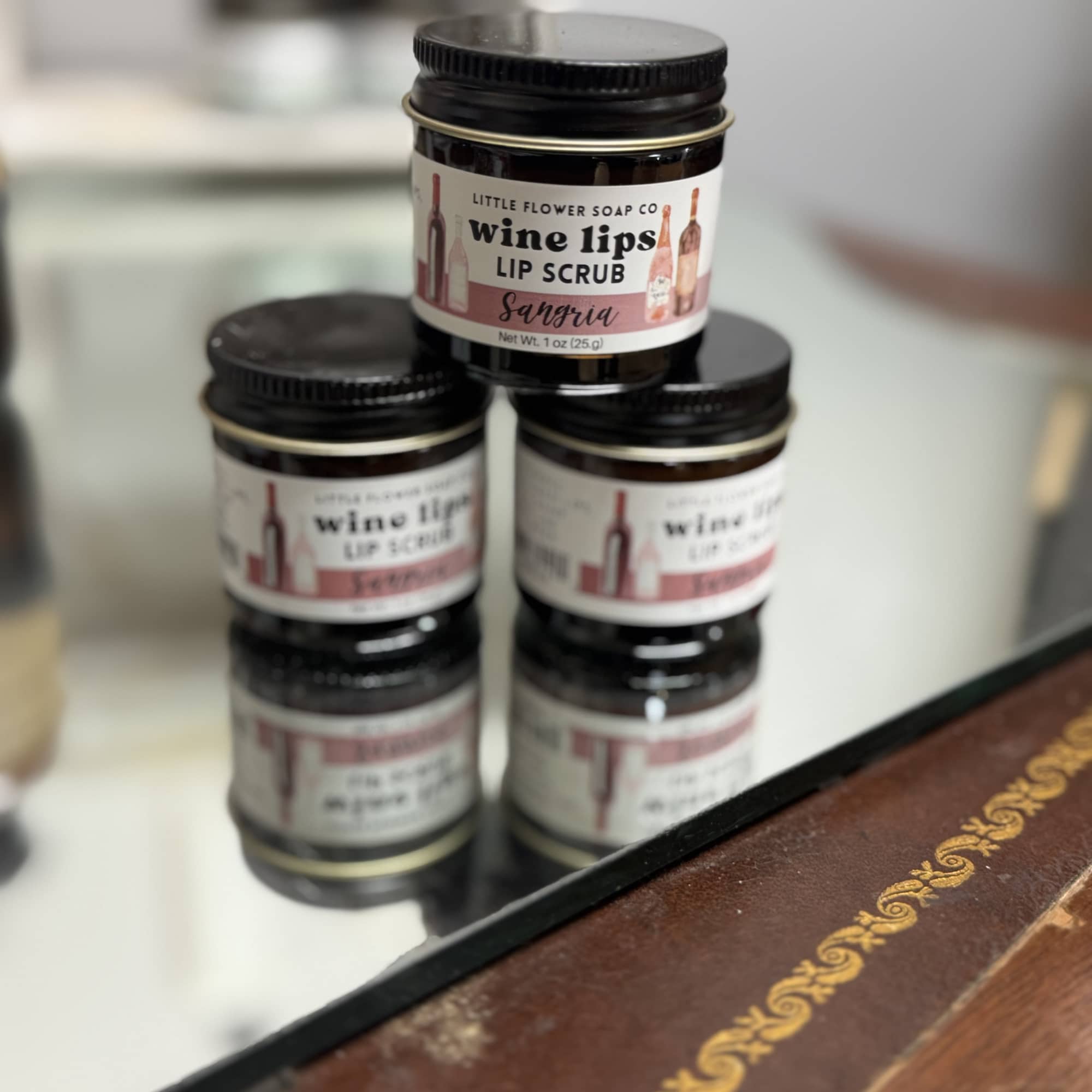 Stacked jars of wine lip scrub on a counter