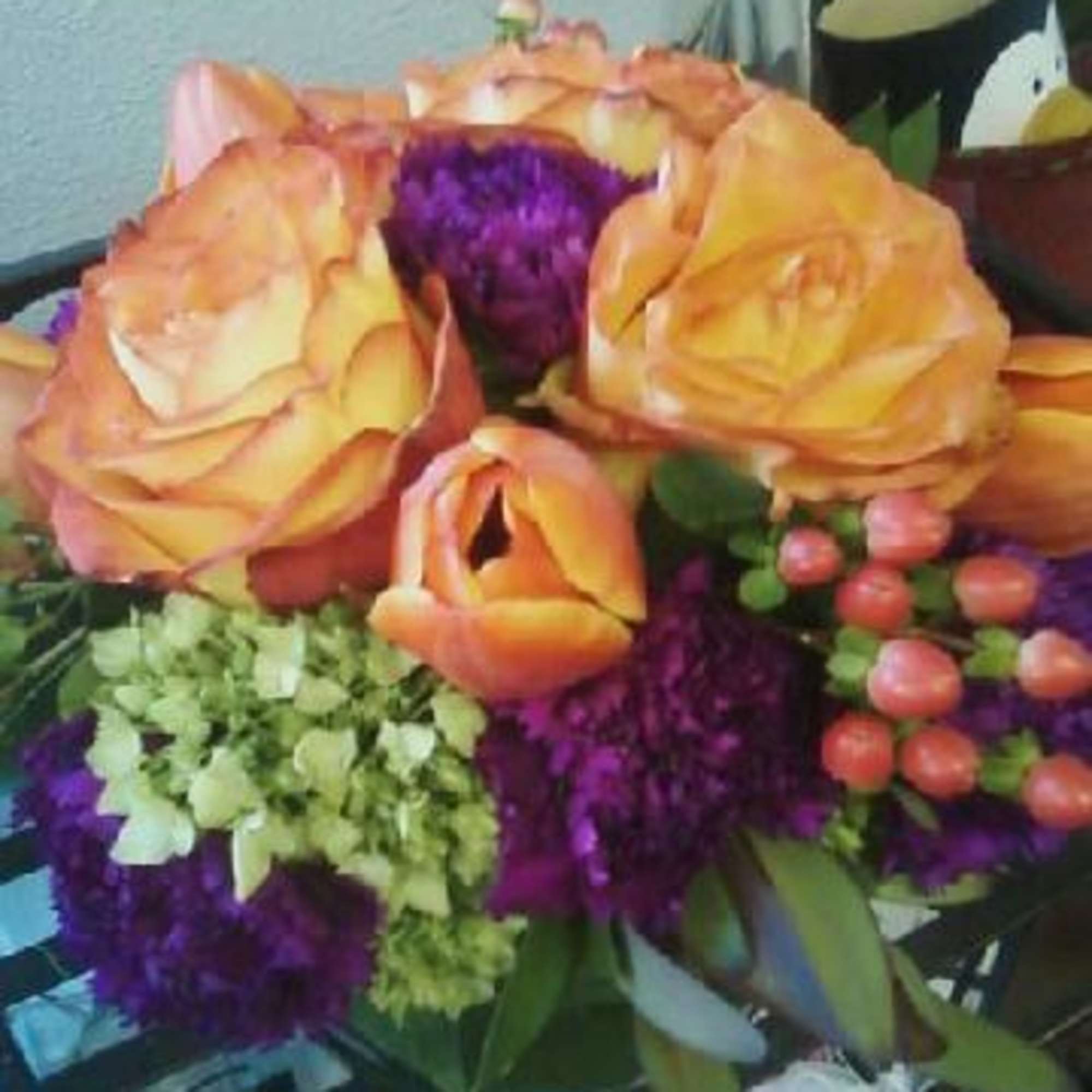 Bouquet of peach roses with purple flowers and green filler