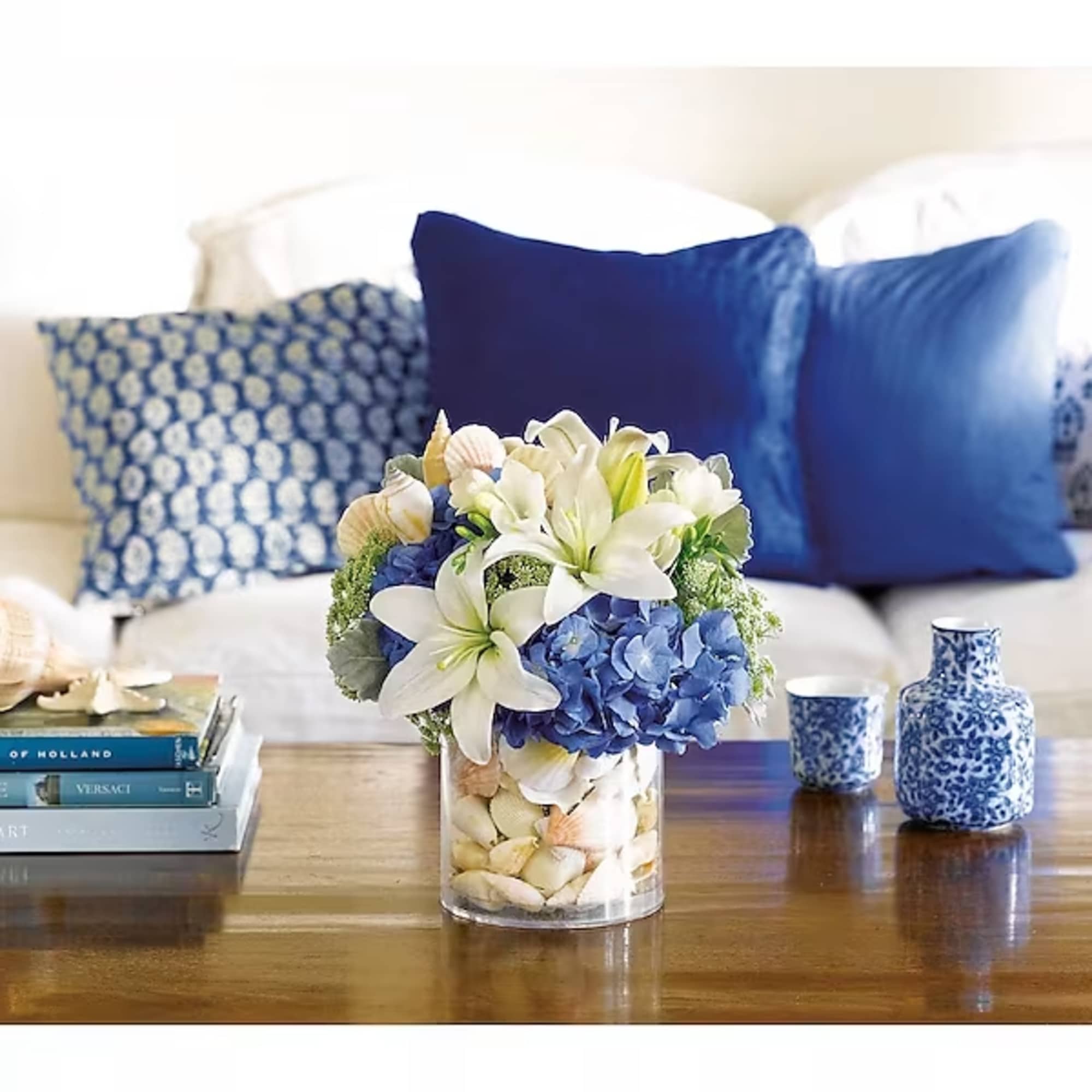 Blue and white floral arrangement in a clear glass vase on a table