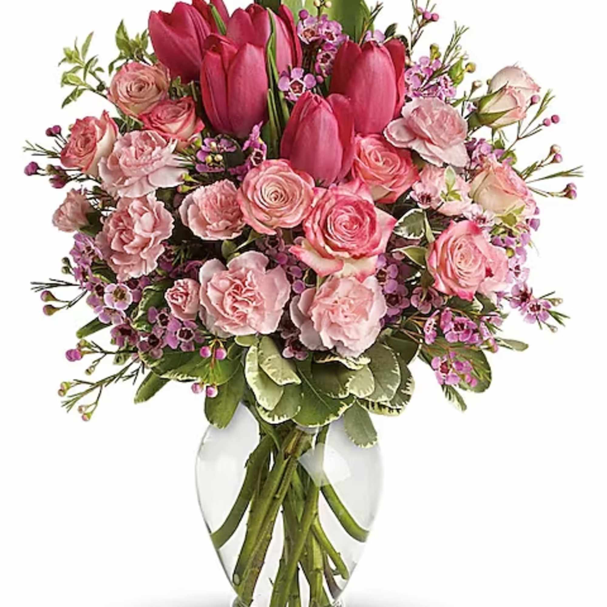 Pink tulips and roses arranged in a clear glass vase
