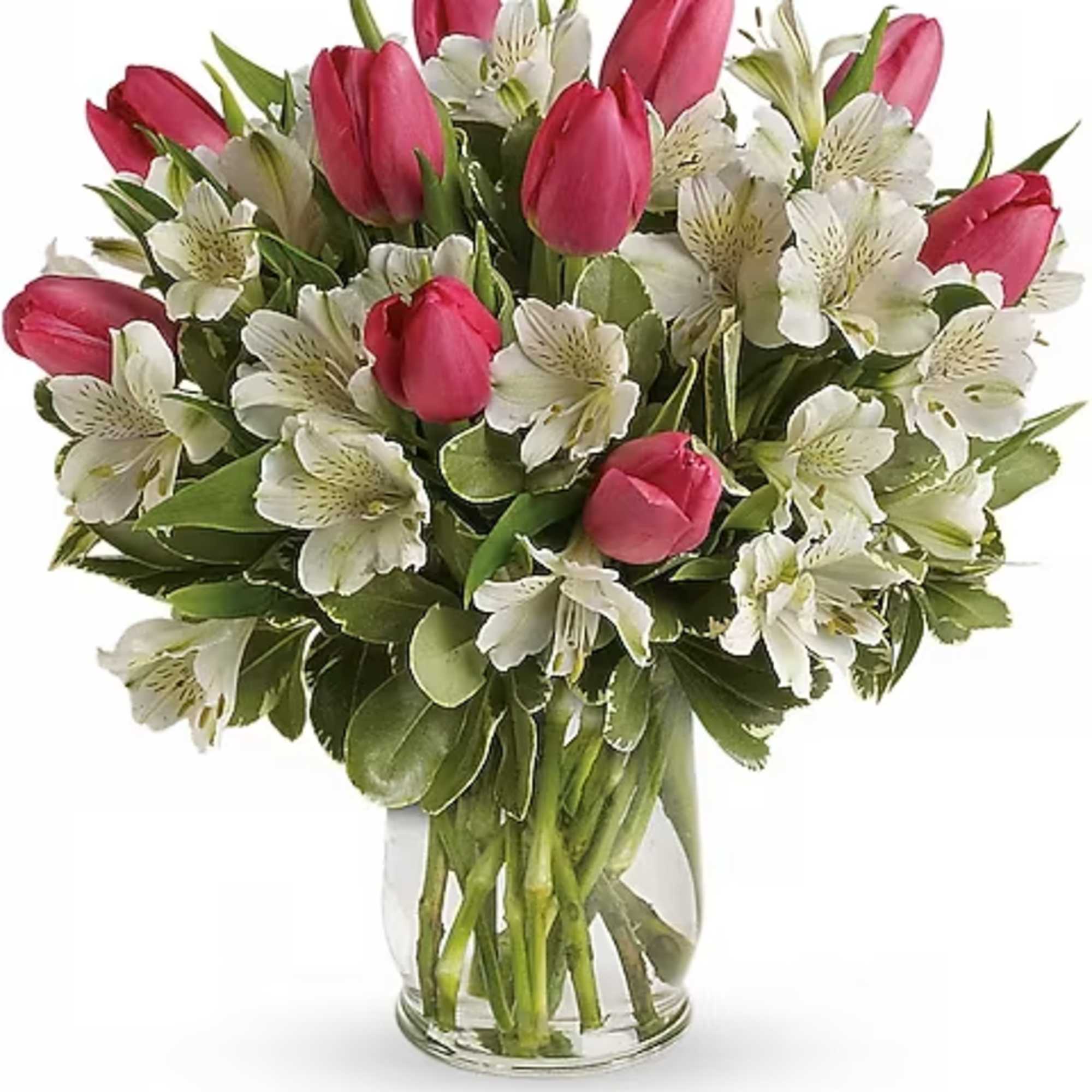 Pink tulips and white alstroemeria in a clear glass vase