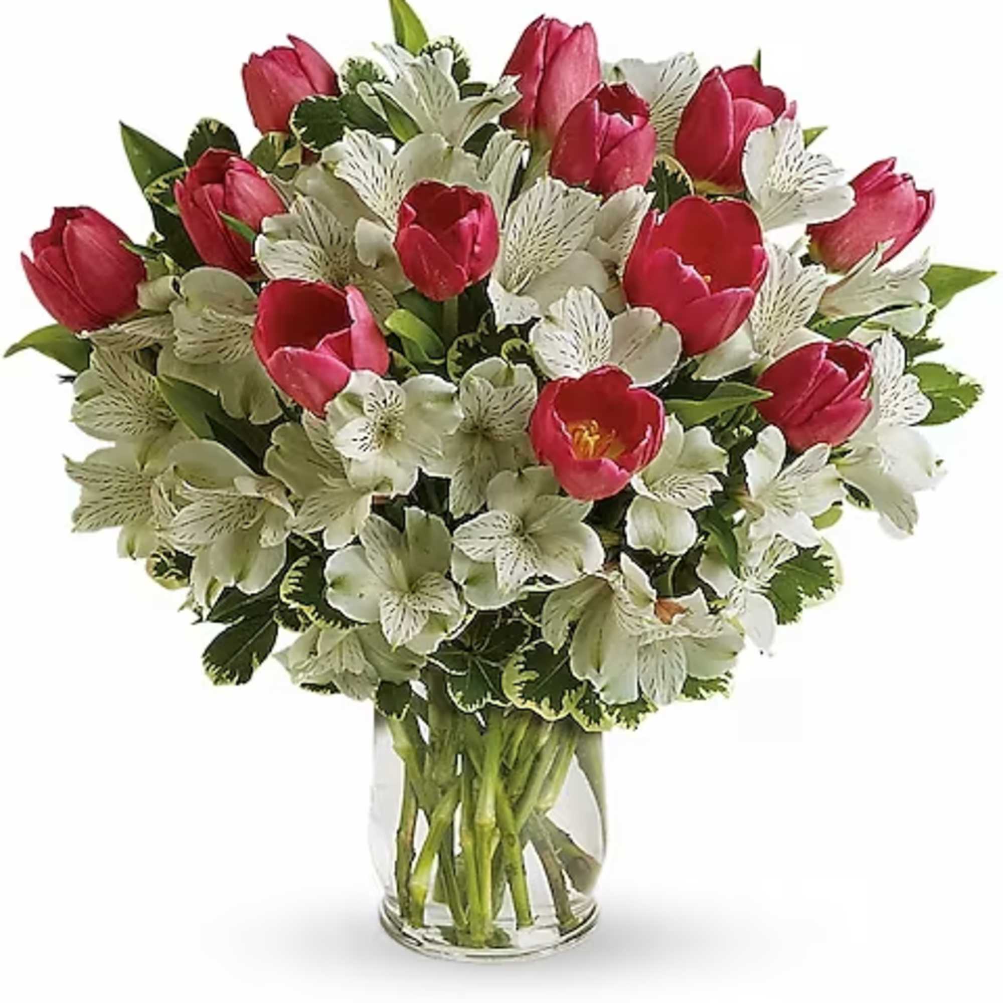 Bouquet of red tulips and white alstroemeria in a clear glass vase