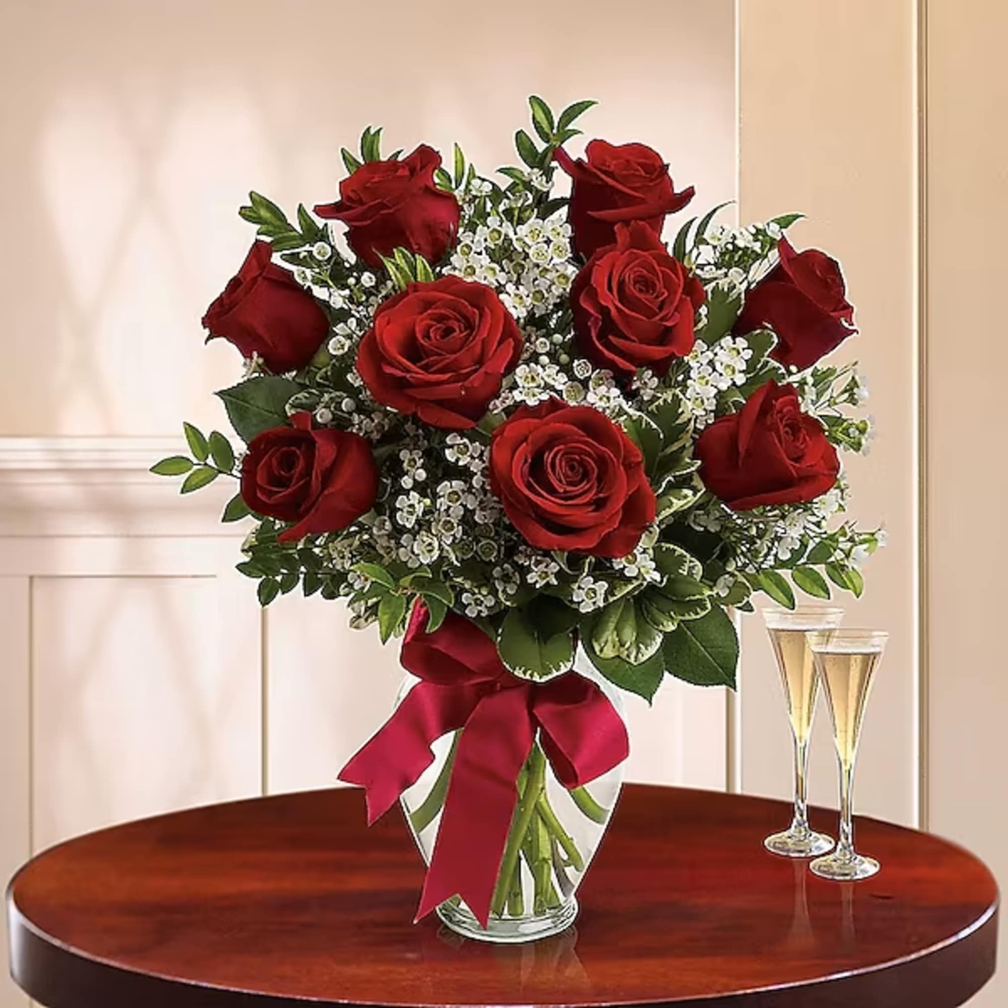 Bouquet of red roses in a glass vase with a red ribbon