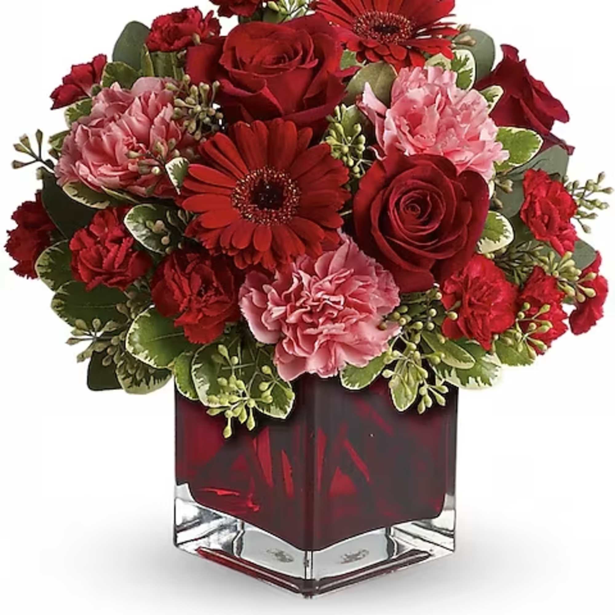 Red and pink floral arrangement in a square glass vase