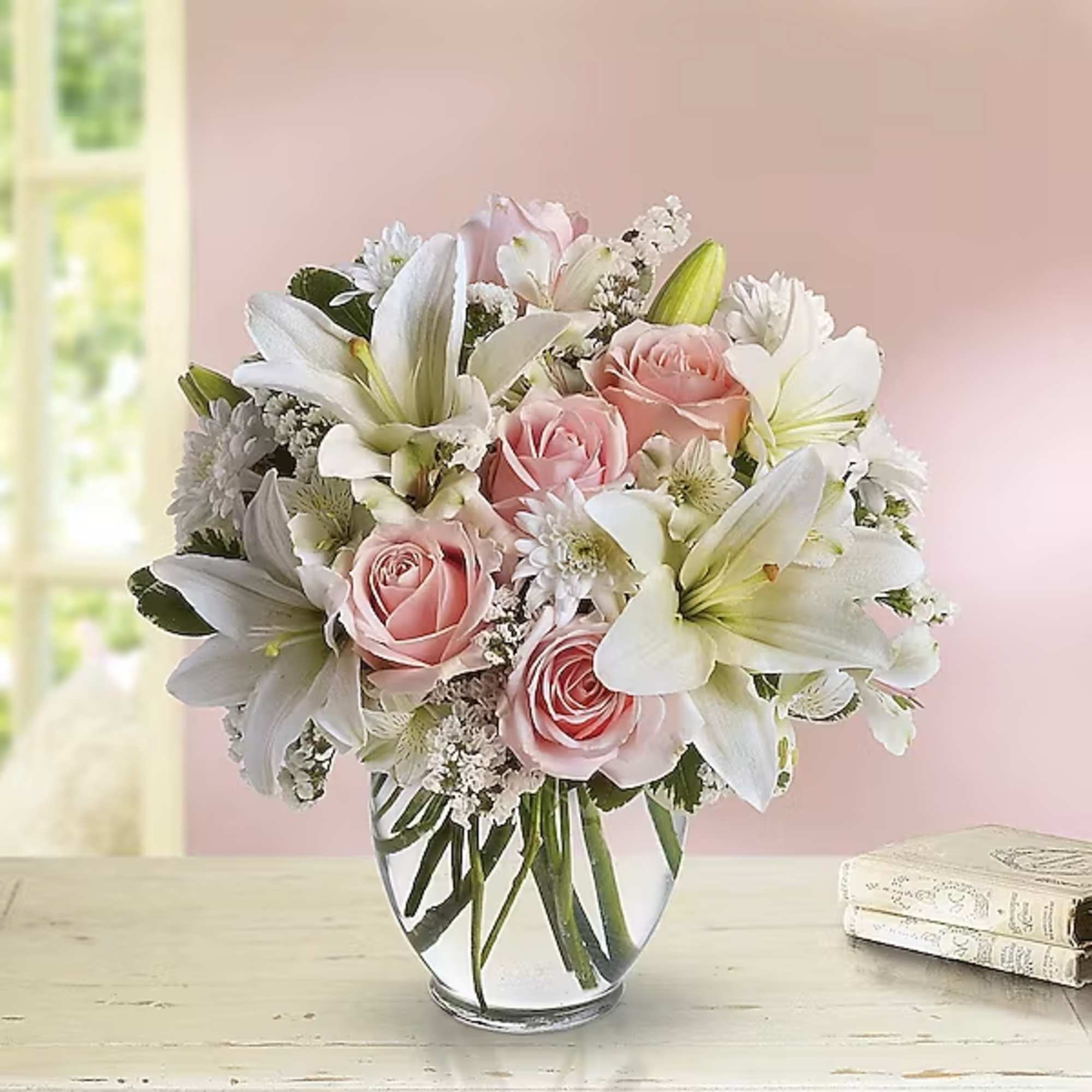 Pink roses and white lilies arranged in a clear glass vase, photo 2 of 2