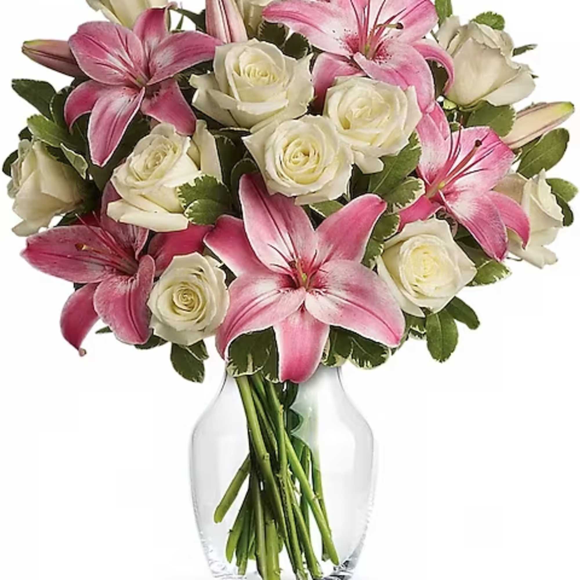 Pink lilies and white roses arranged in a clear glass vase