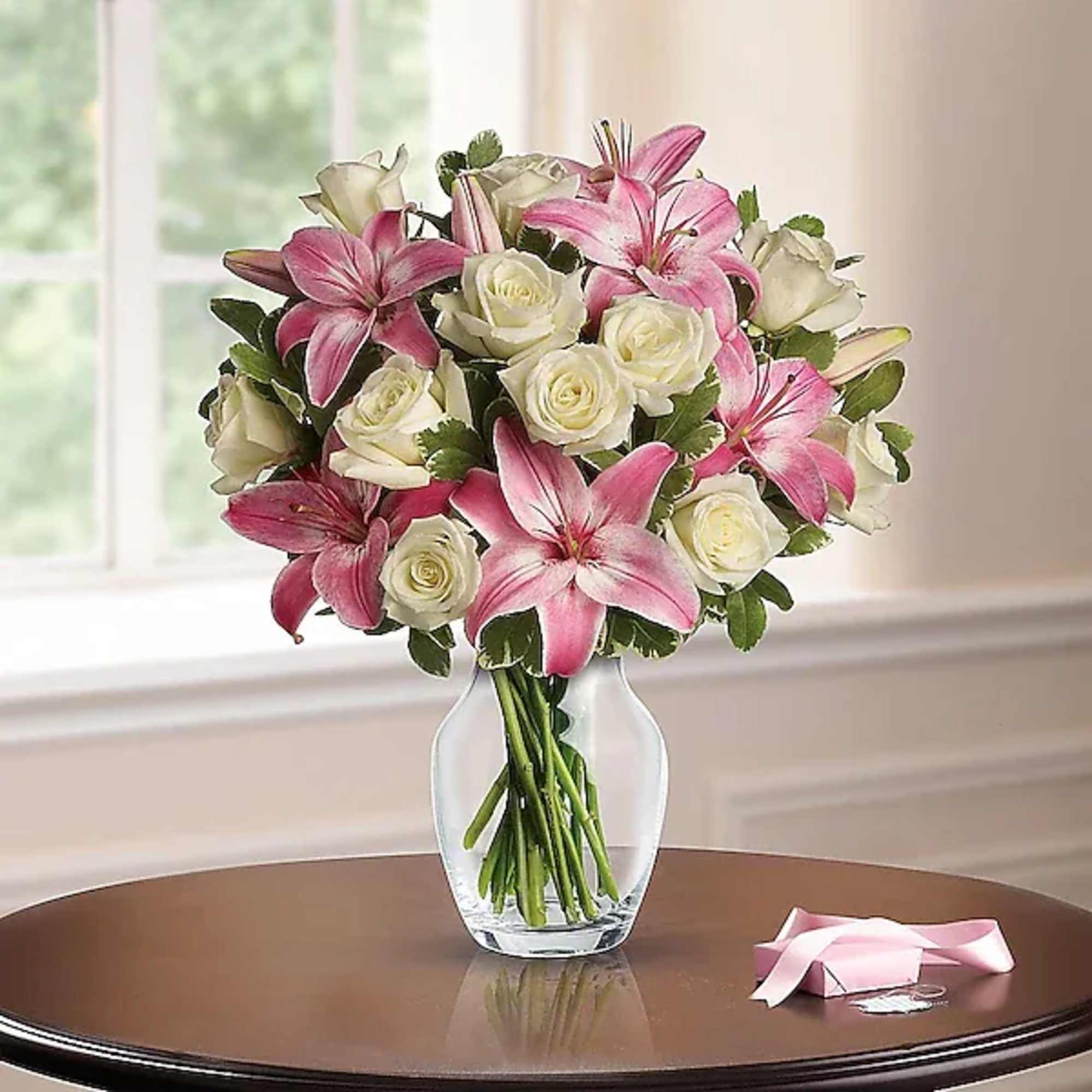 Pink lilies and white roses in a clear glass vase