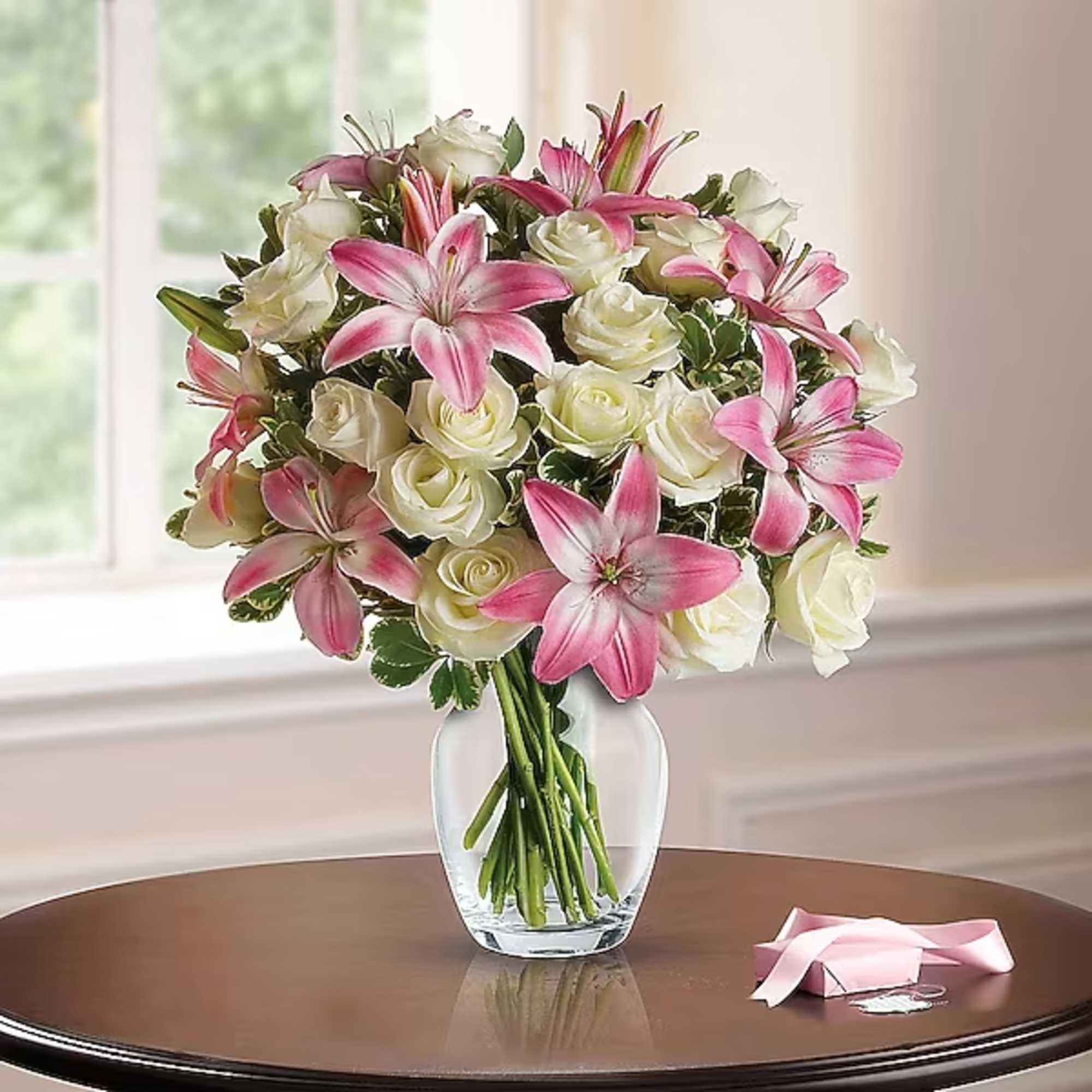 Pink lilies and white roses in a clear glass vase, photo 2 of 2