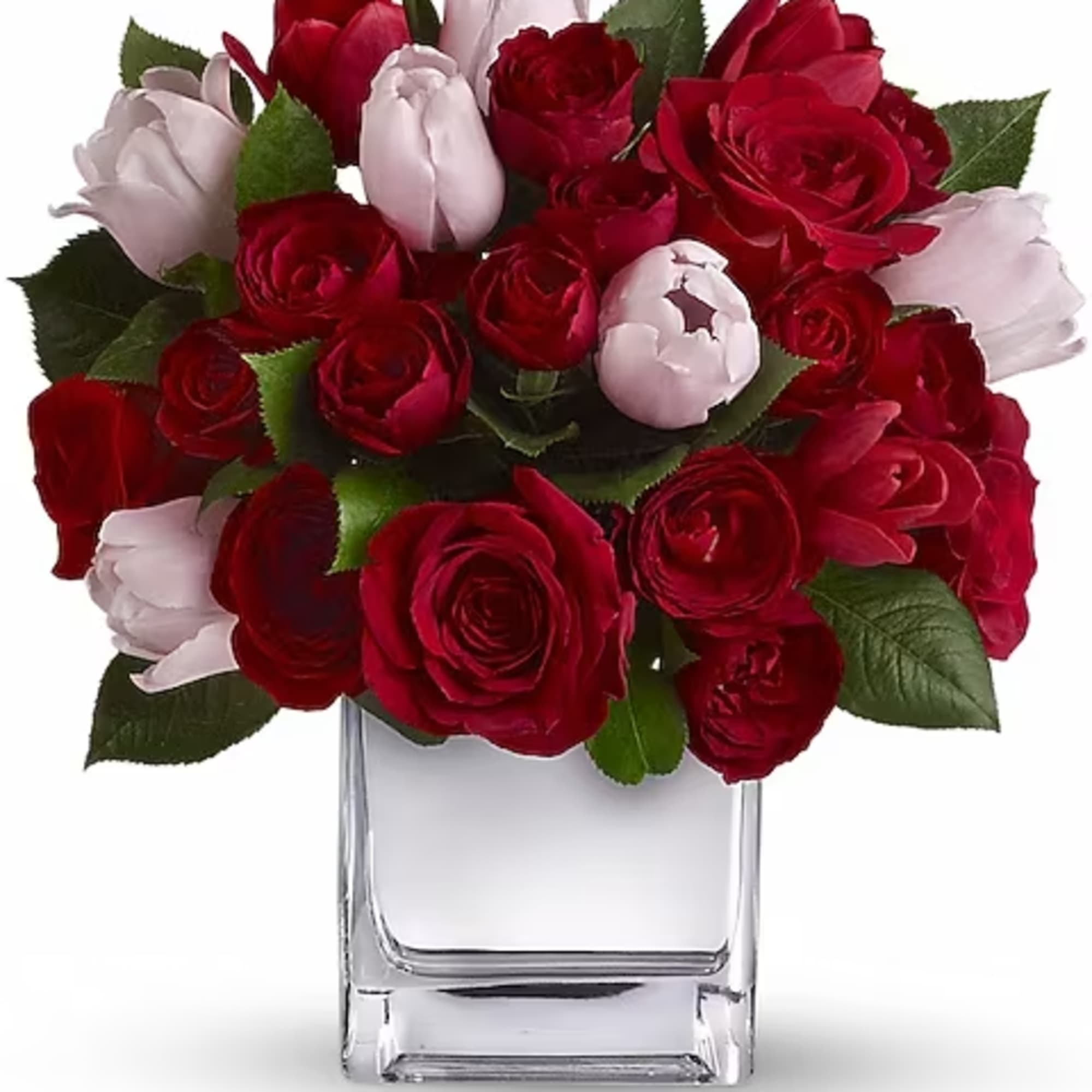 Red and pale pink roses arranged in a clear glass vase