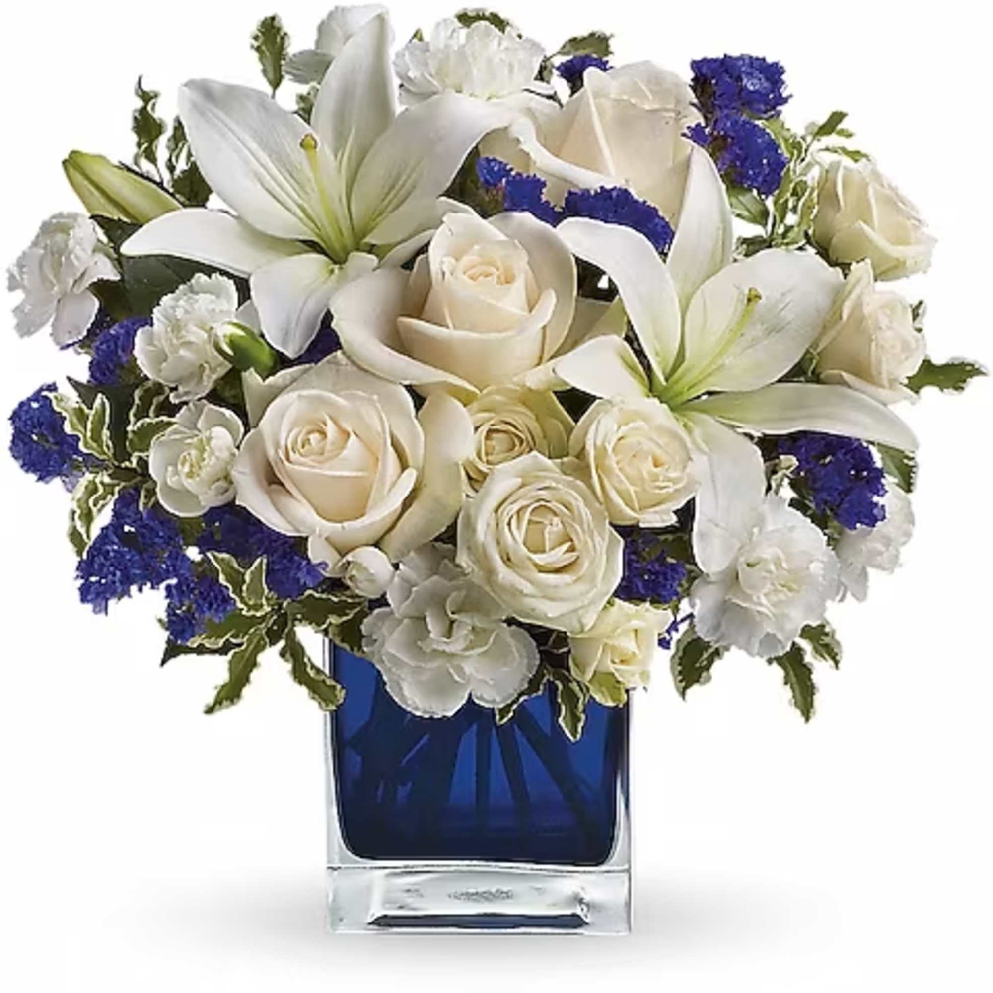 White roses and lilies arranged in a blue glass vase