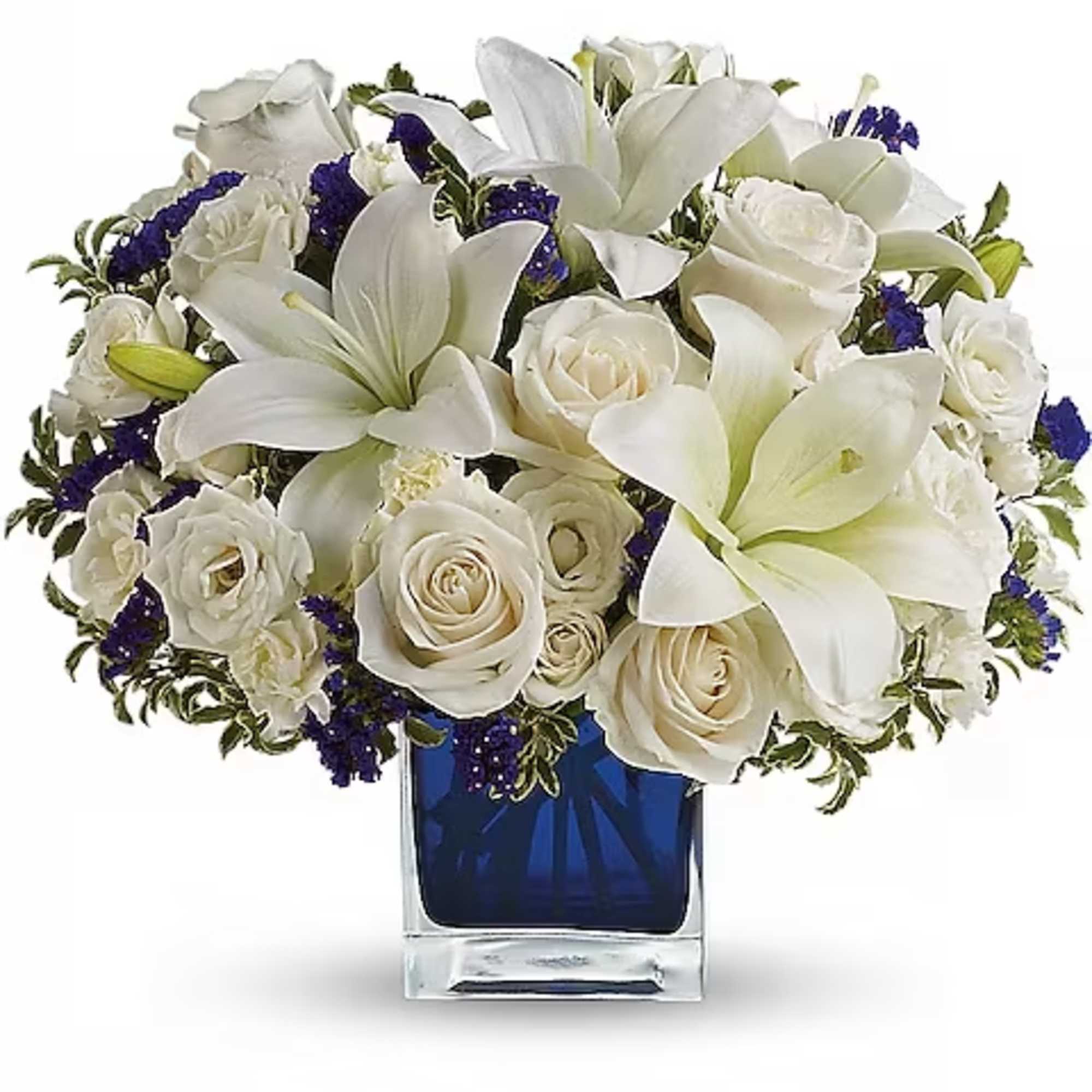 White roses and lilies arranged in a blue glass vase