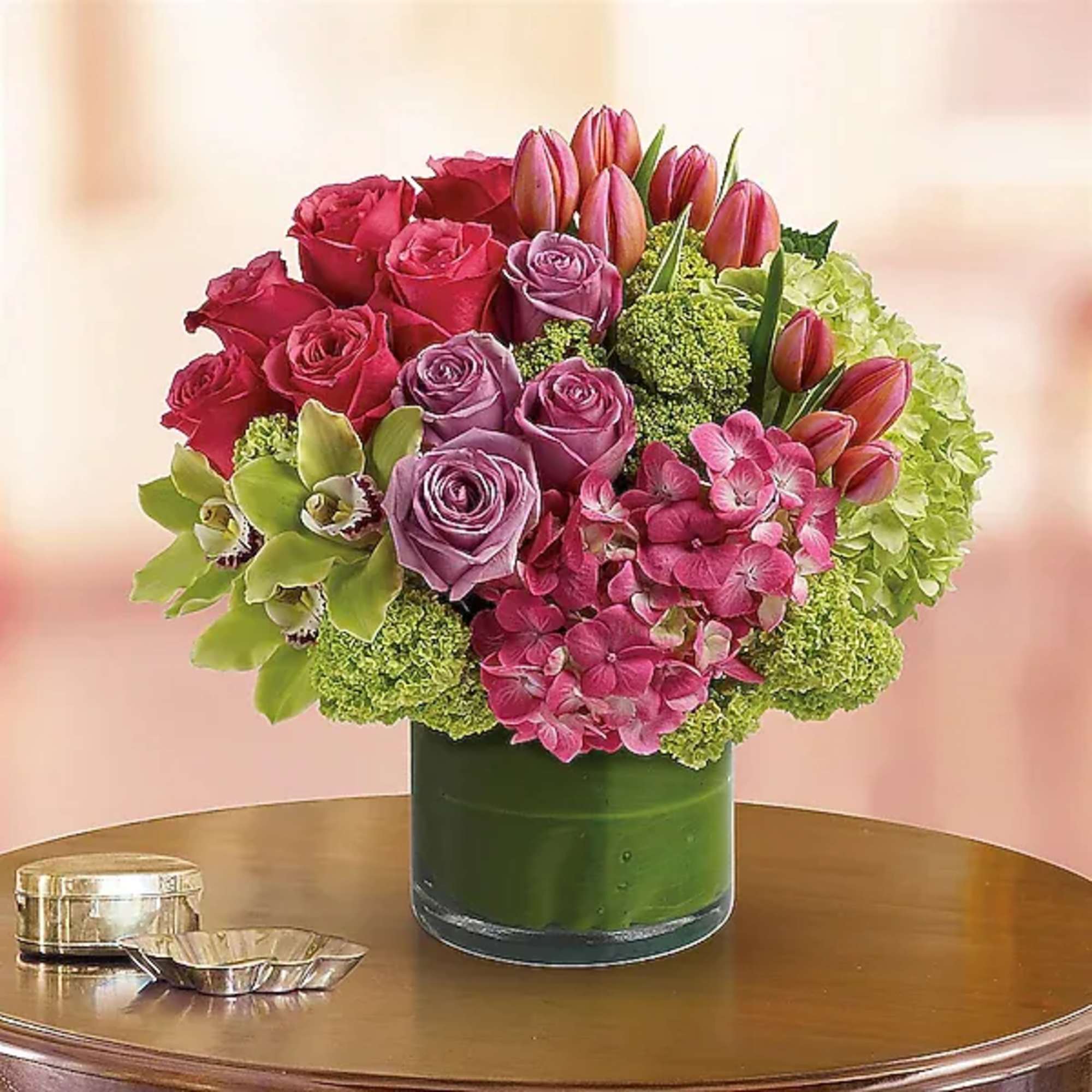 Pink and lavender roses with tulips and hydrangeas in a green vase