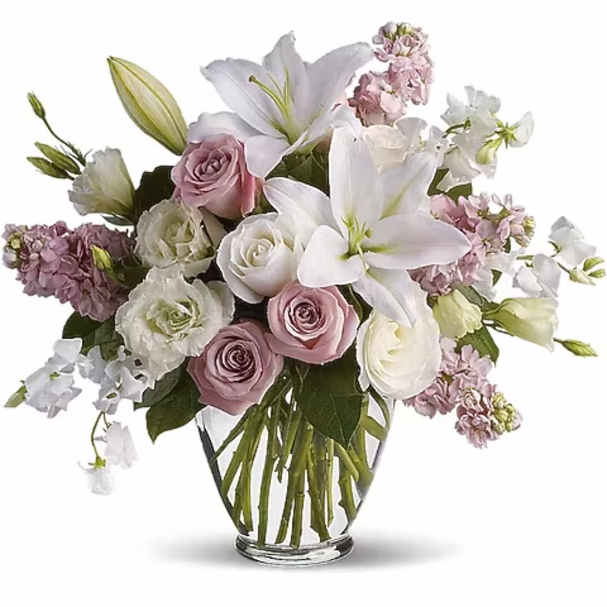 Bouquet of white lilies, roses, and pink flowers in a clear glass vase