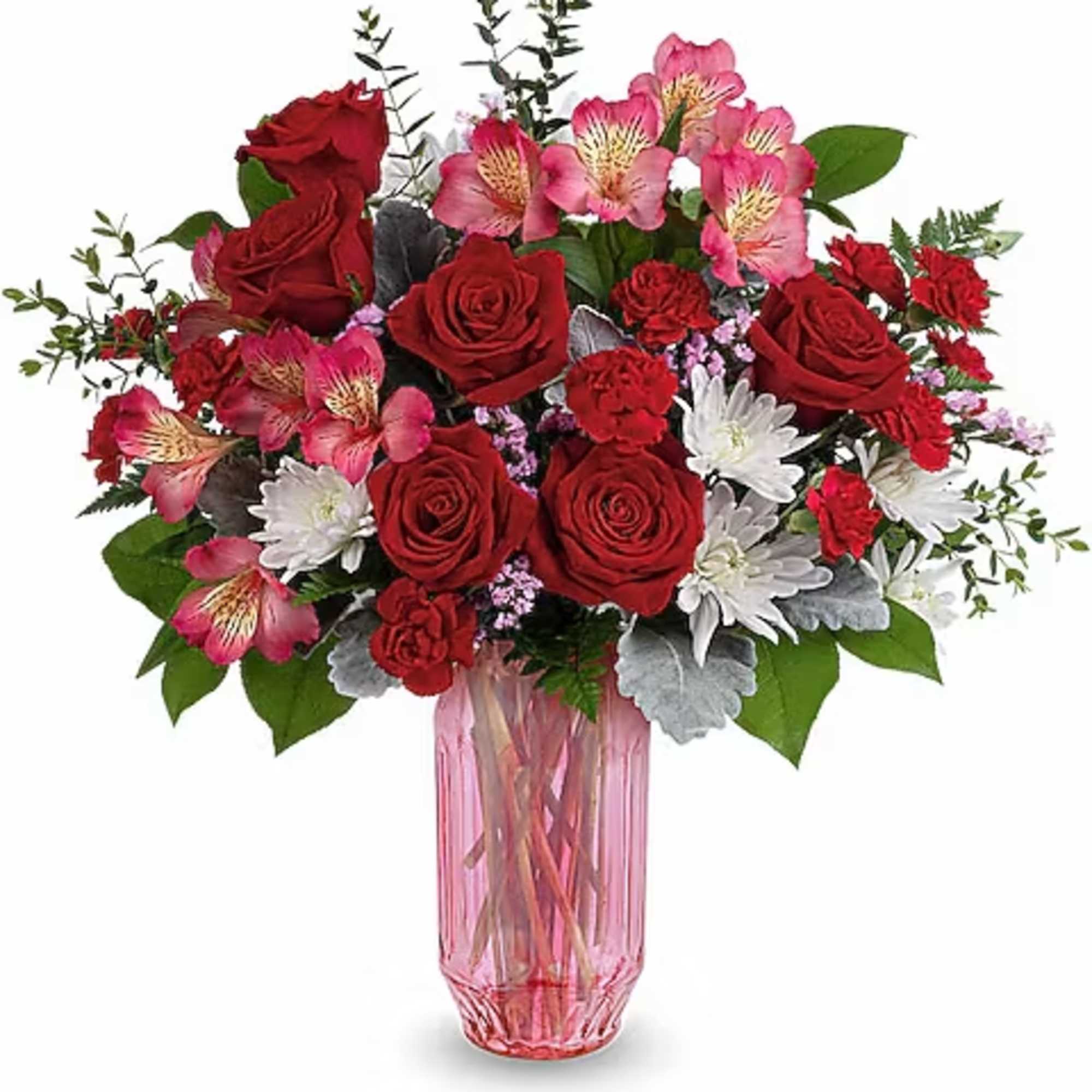 Red roses and pink flowers arranged in a pink glass vase