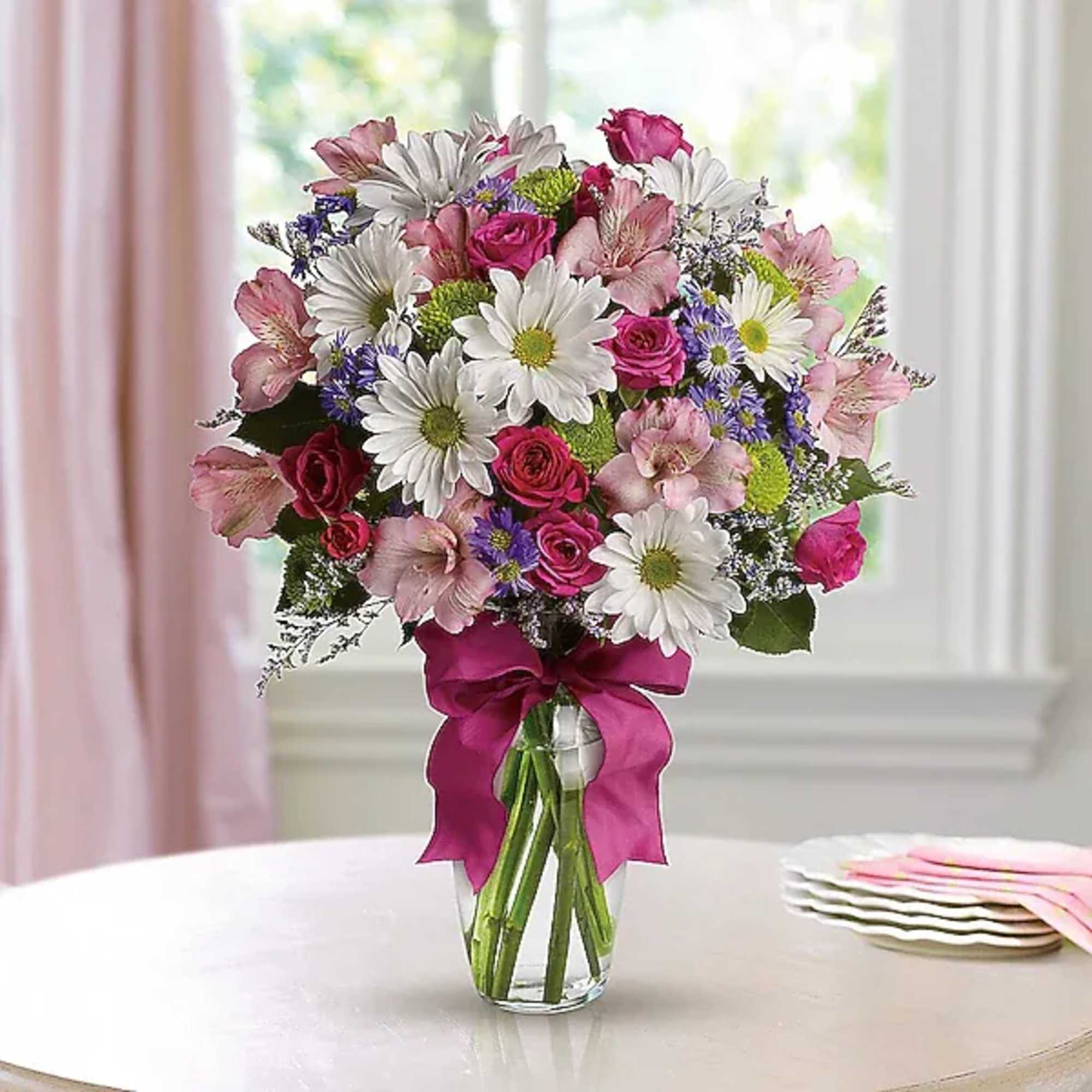 Mixed bouquet of pink and white flowers in a clear glass vase