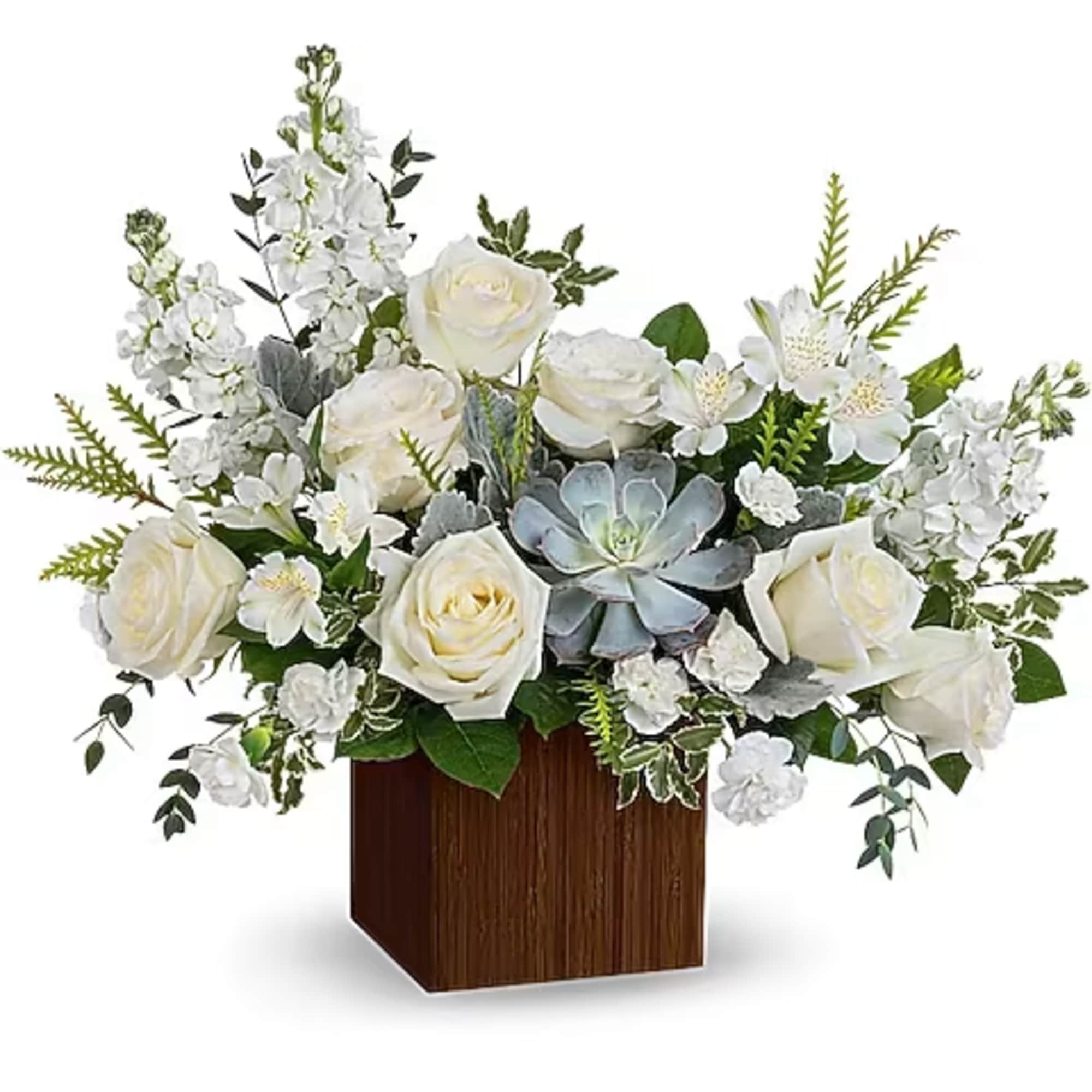 White roses and small white flowers arranged in a wooden cube vase