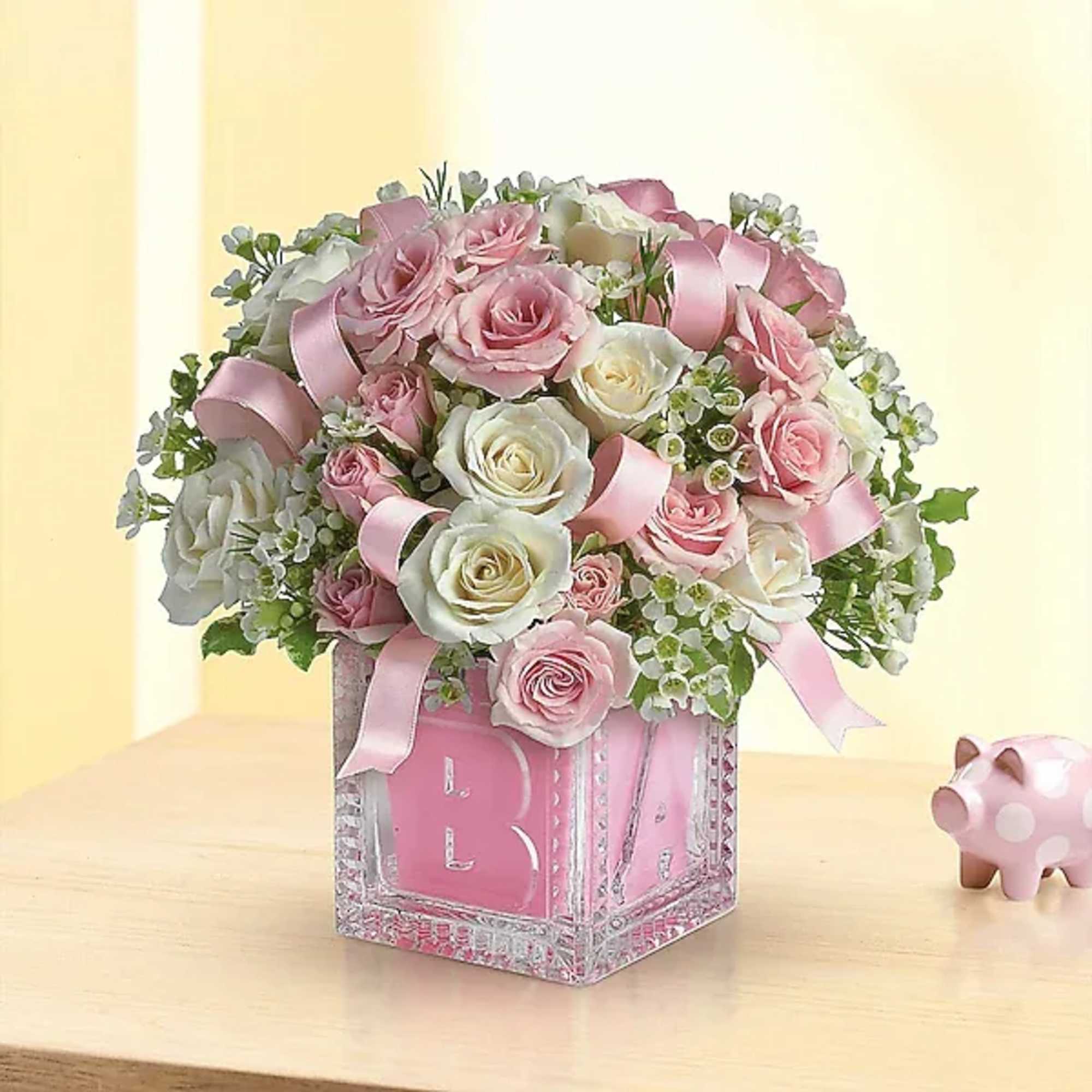 Pink and white rose arrangement in a decorative glass cube vase