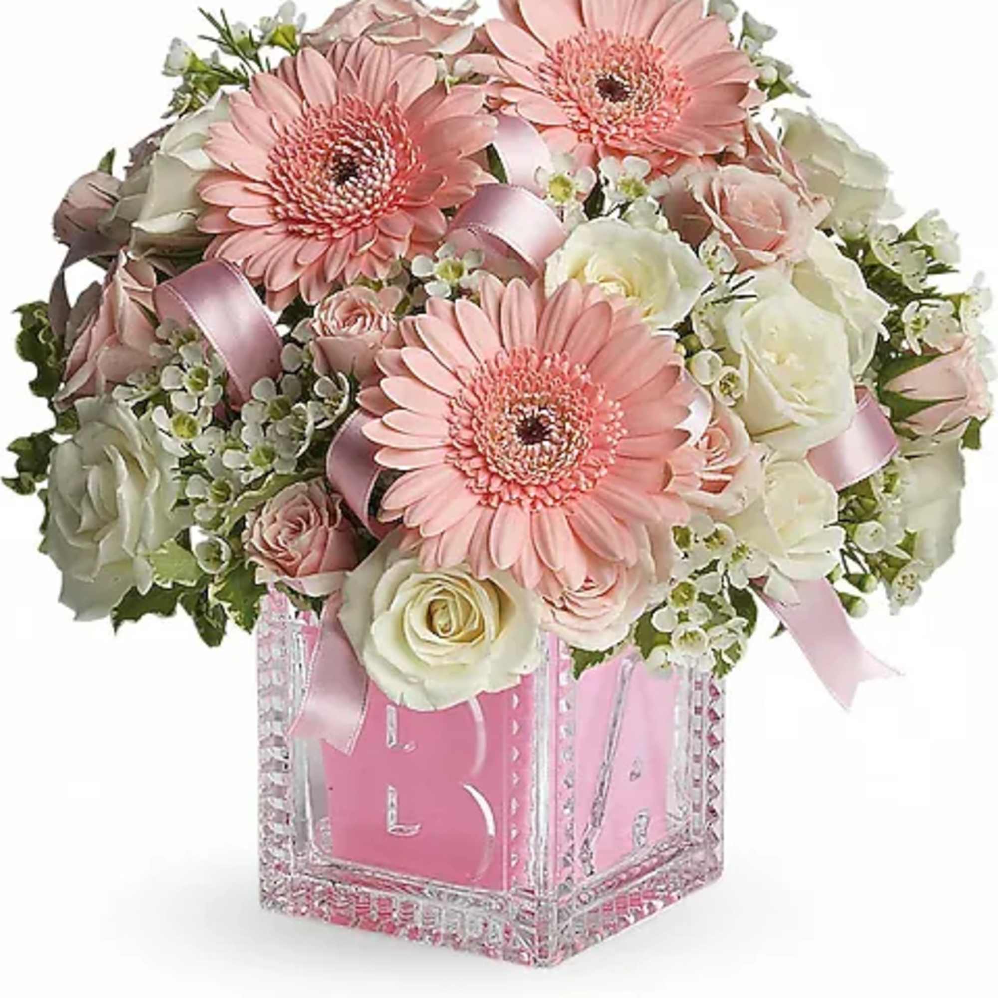 Pink gerbera daisies and white roses in a clear square vase with pink ribbon