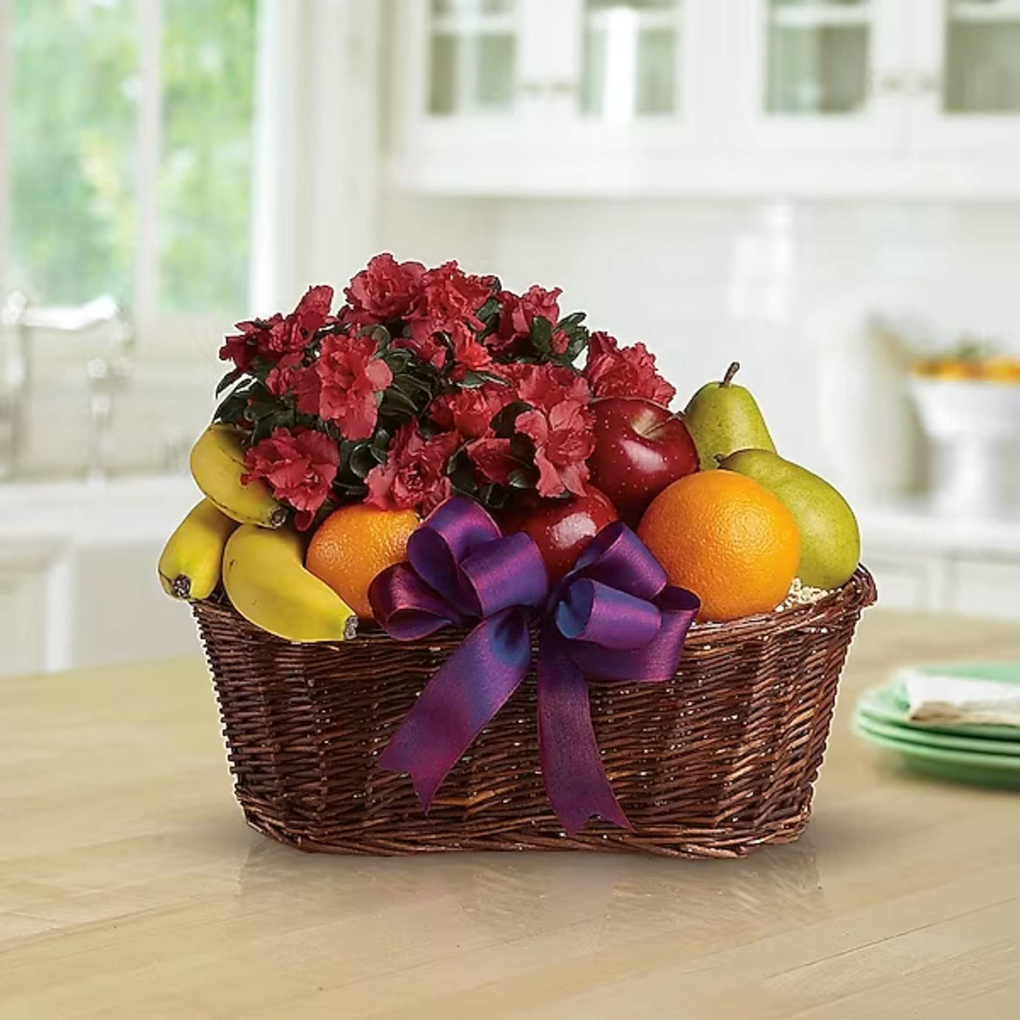 Fruit basket with red flowers and a purple ribbon