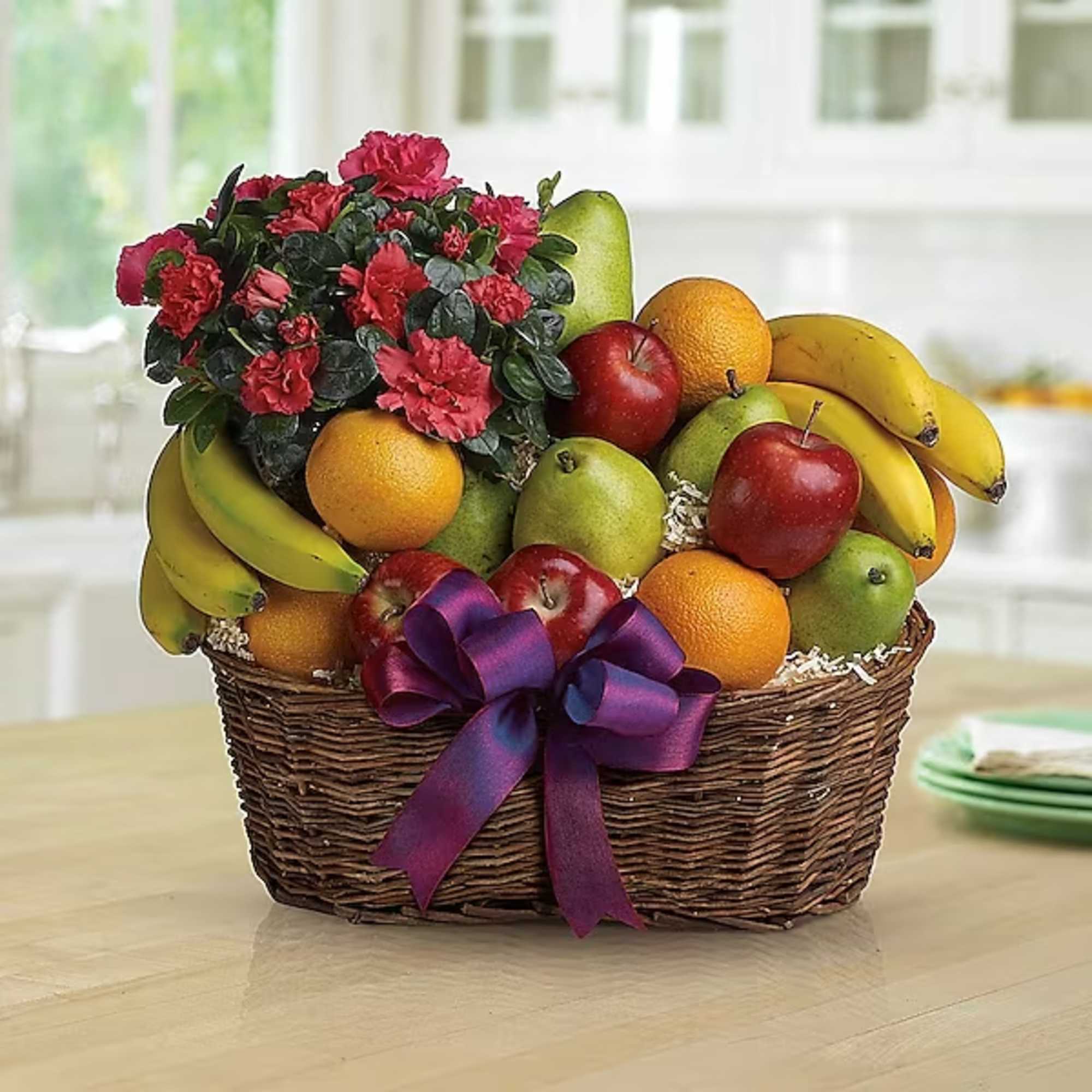 Fruit basket with carnations and a purple ribbon