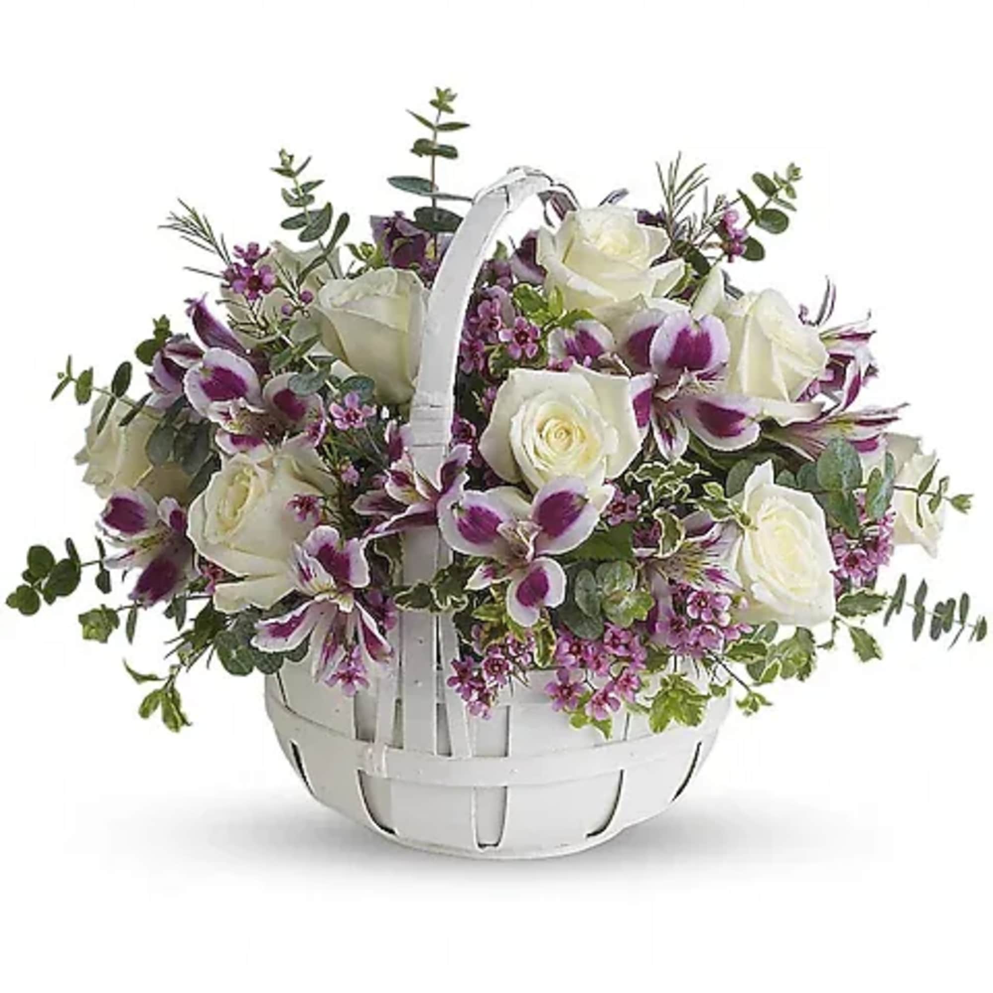White roses and purple orchids in a white basket