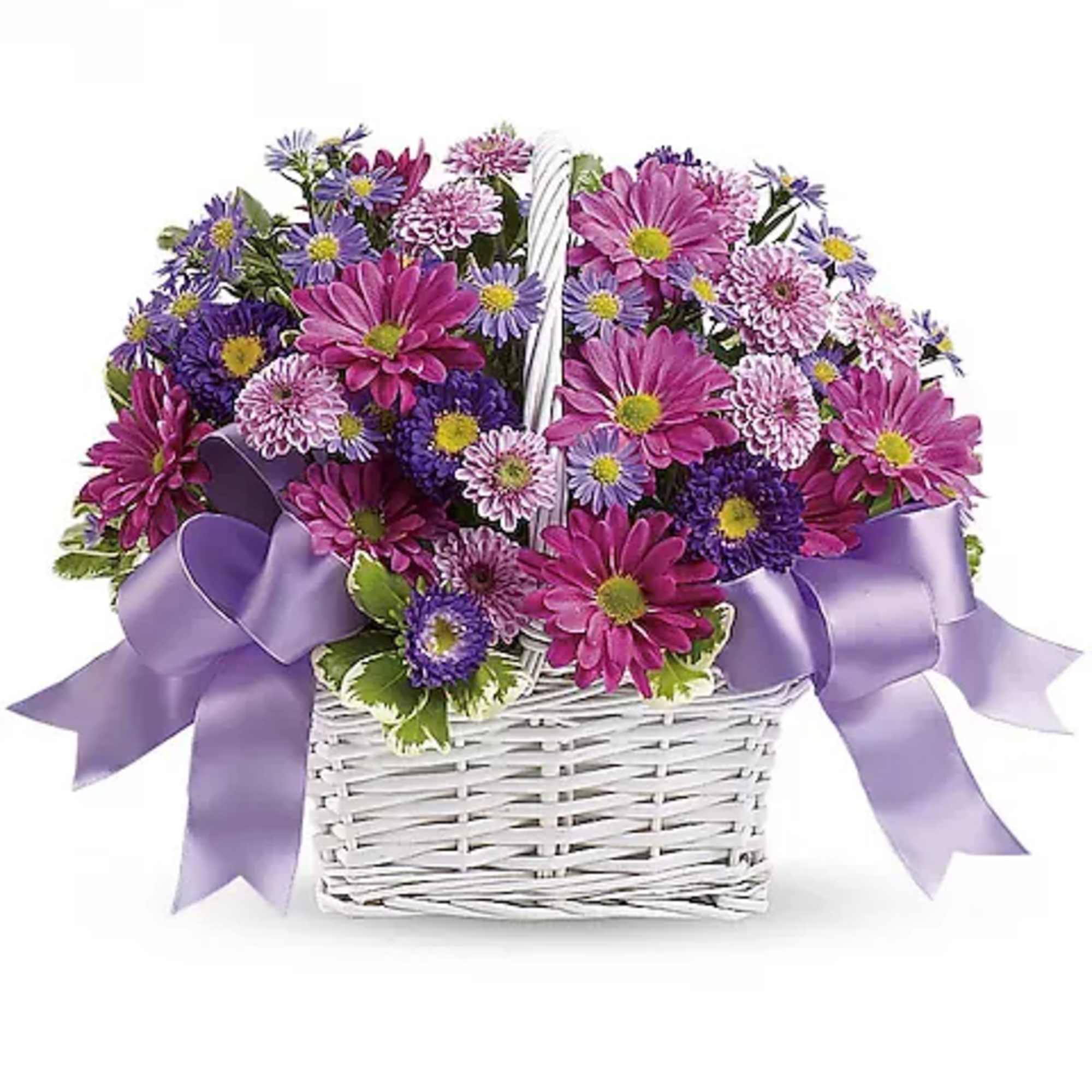 Purple and pink daisy bouquet in a white basket with lavender ribbon