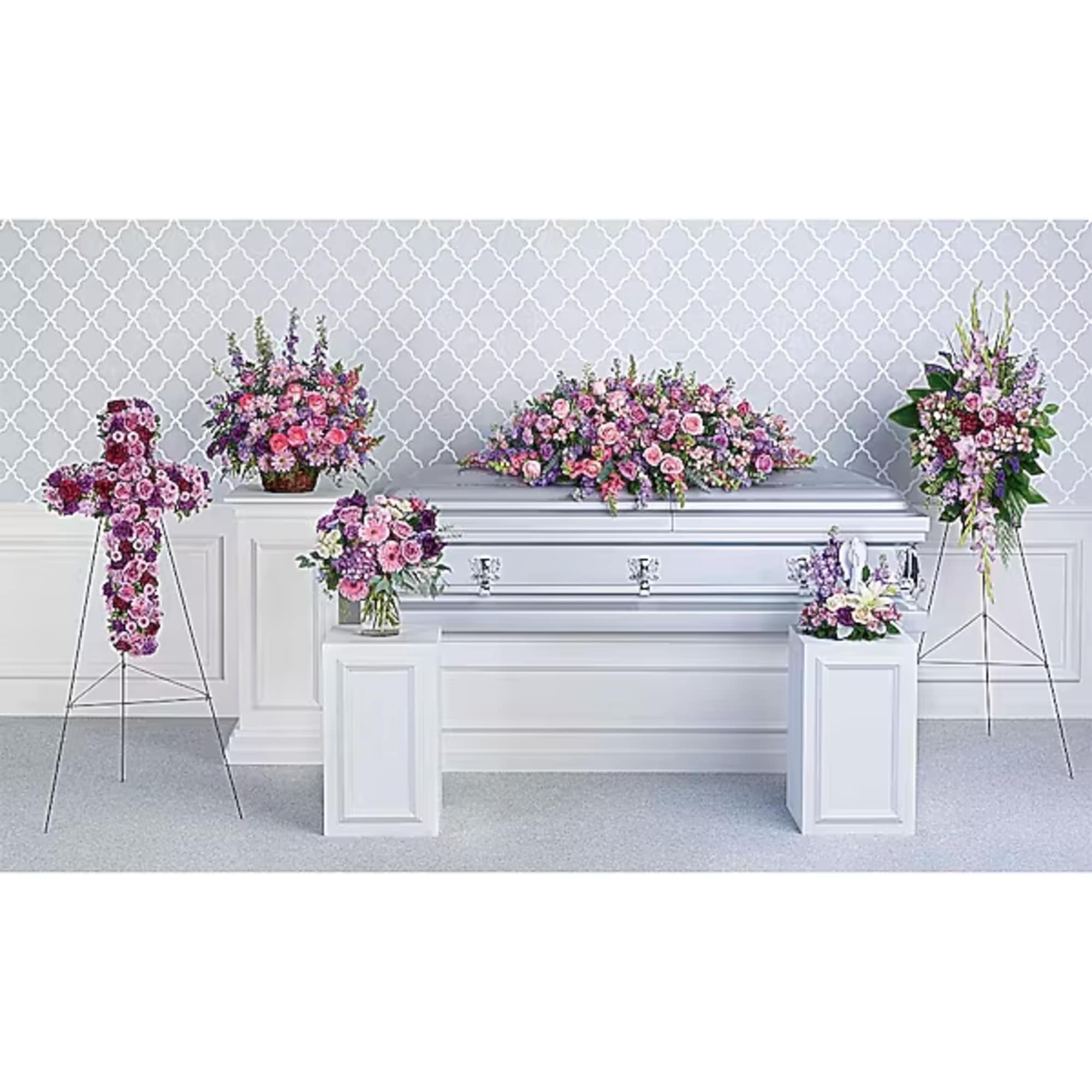 Floral funeral casket spray with pink and purple flowers on a white casket