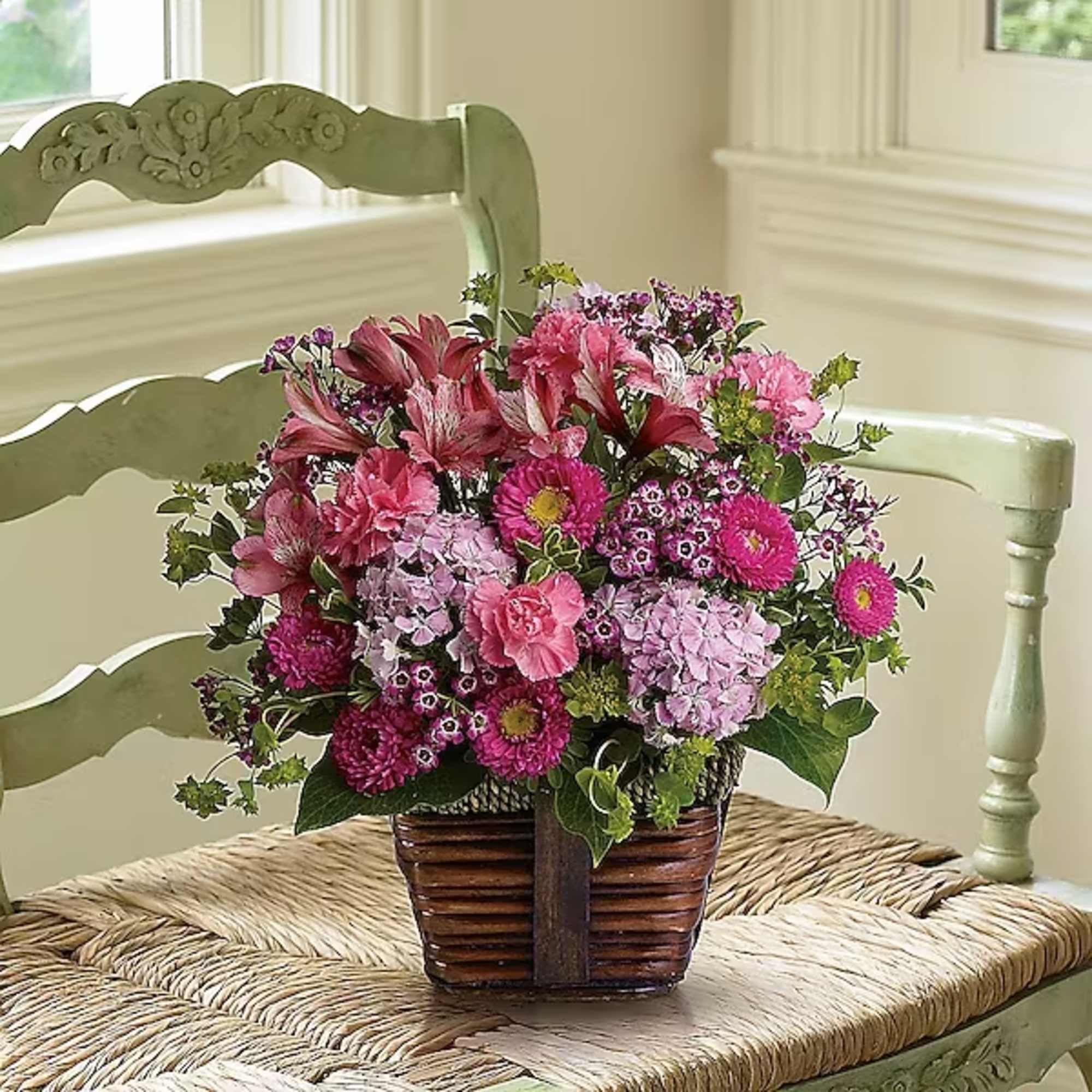 Pink mixed flower arrangement in a woven basket