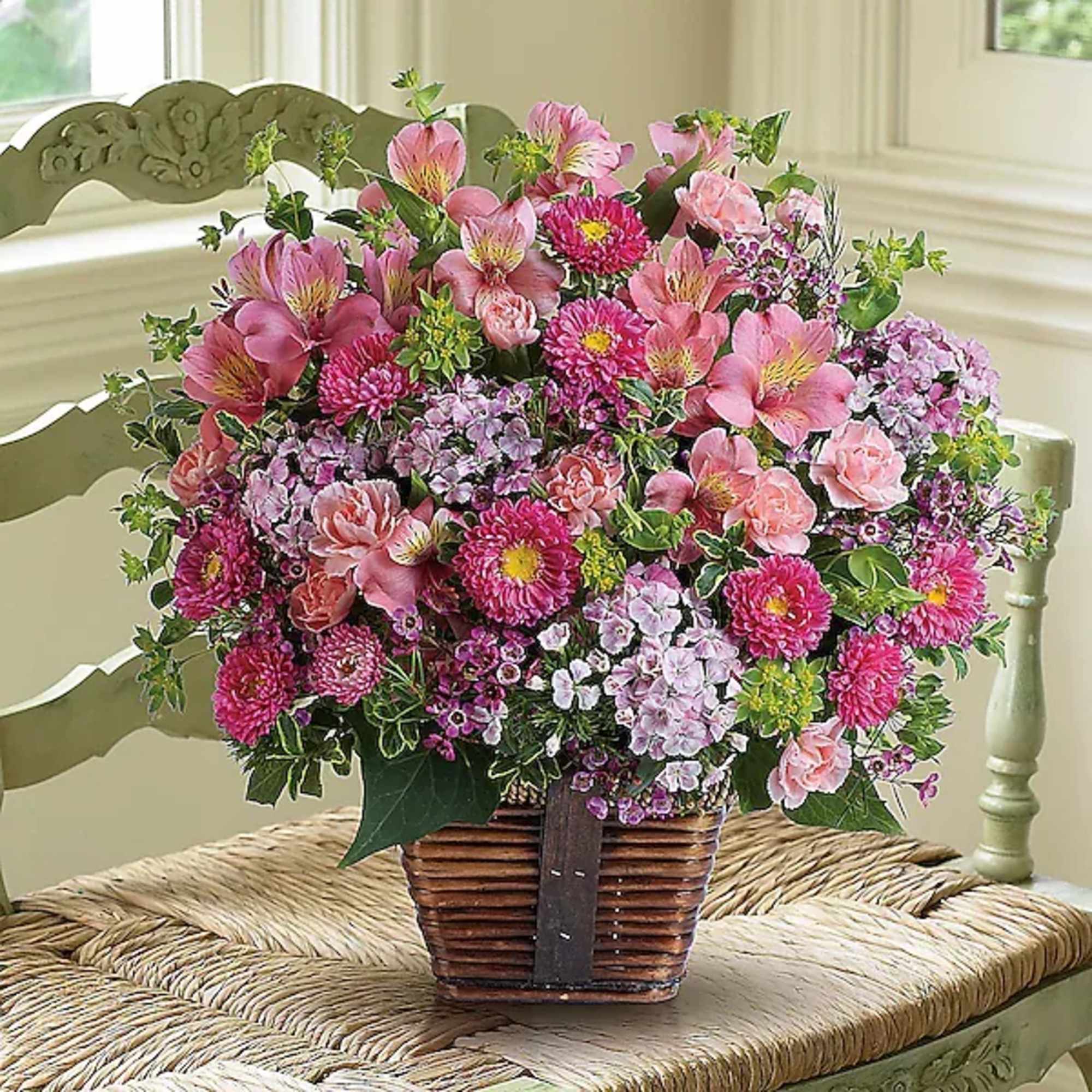 Pink mixed flower arrangement in a wicker basket