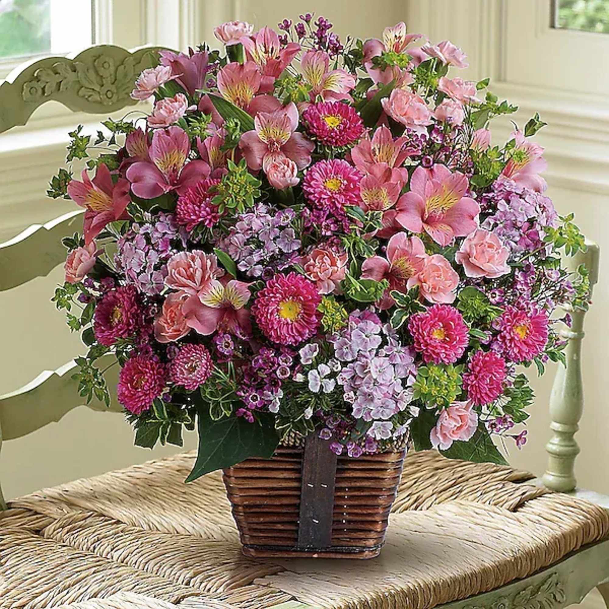Pink mixed flower arrangement in a woven basket