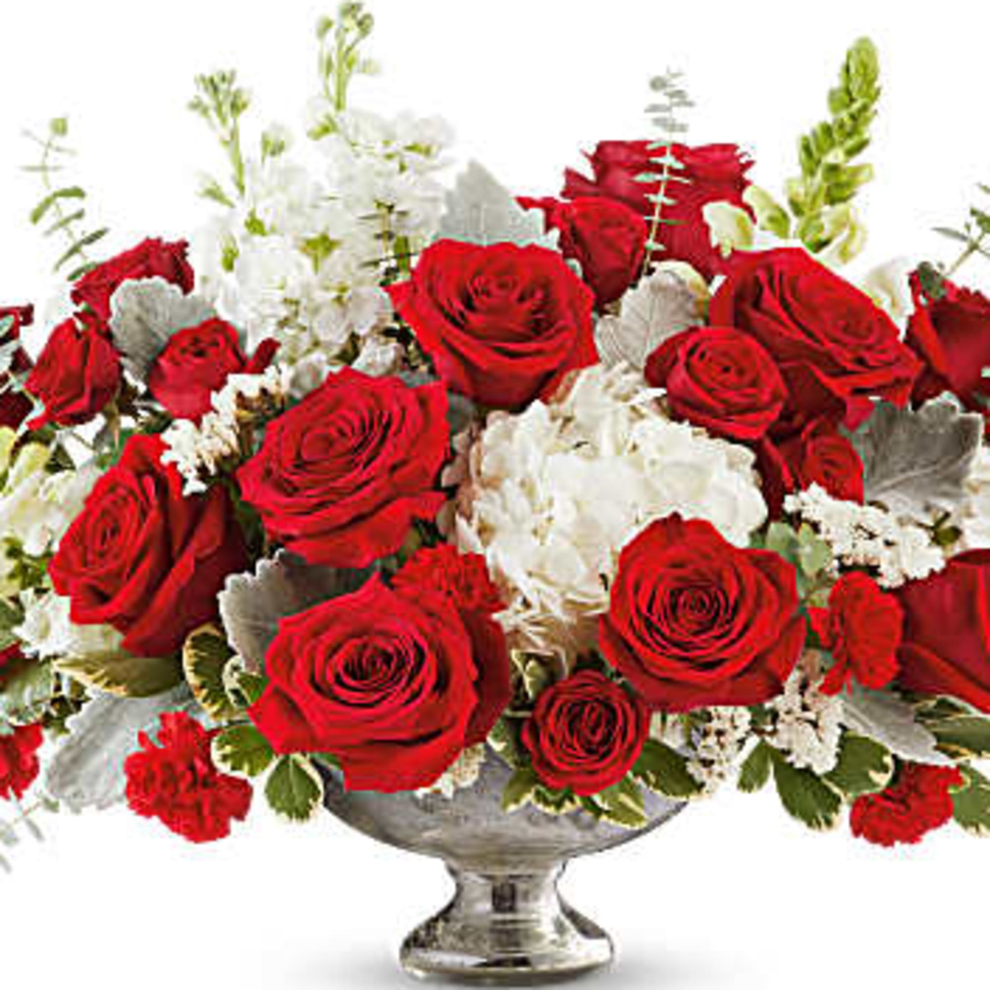 Red roses and white flowers arranged in a silver pedestal vase
