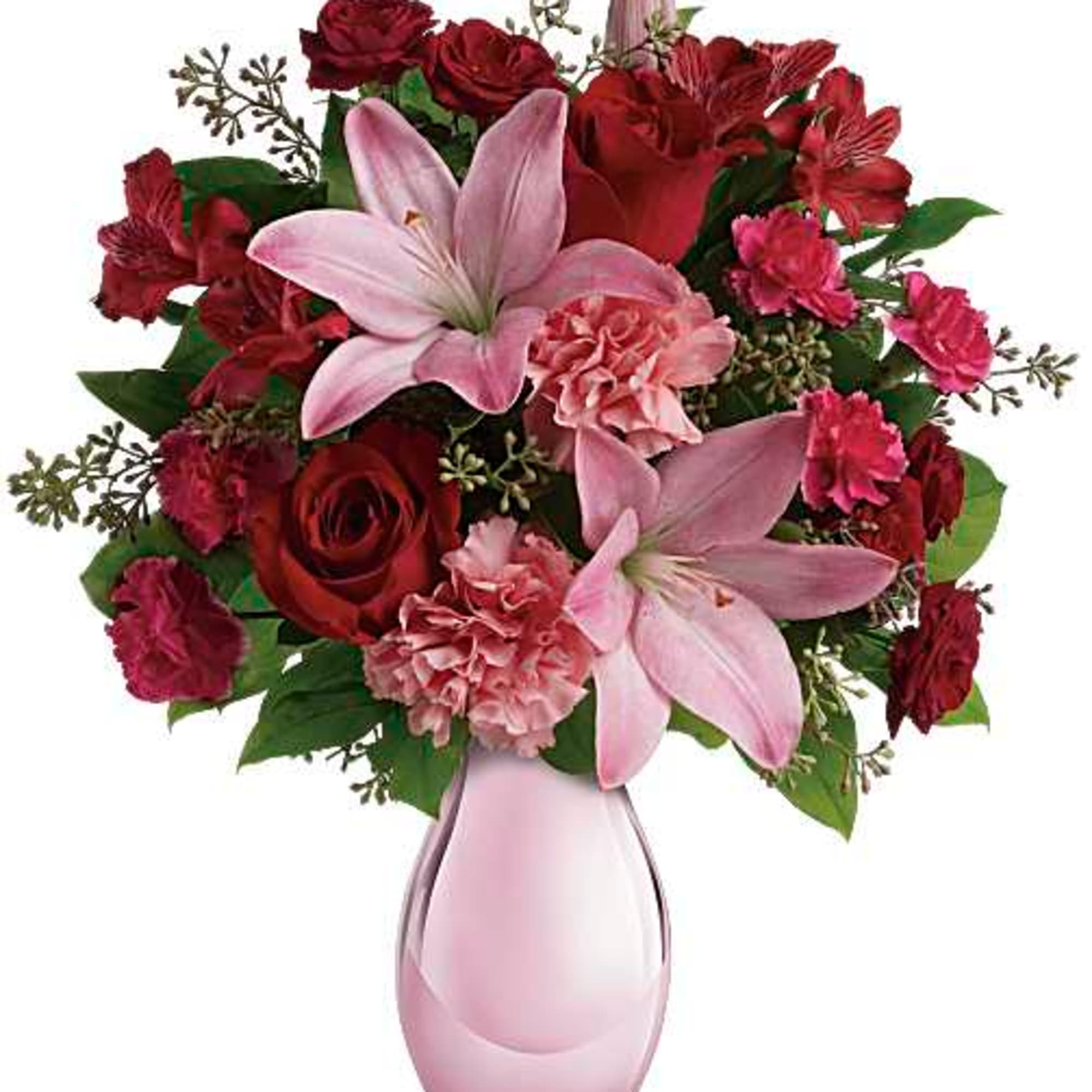 Pink lilies and red roses arranged in a pink glass vase