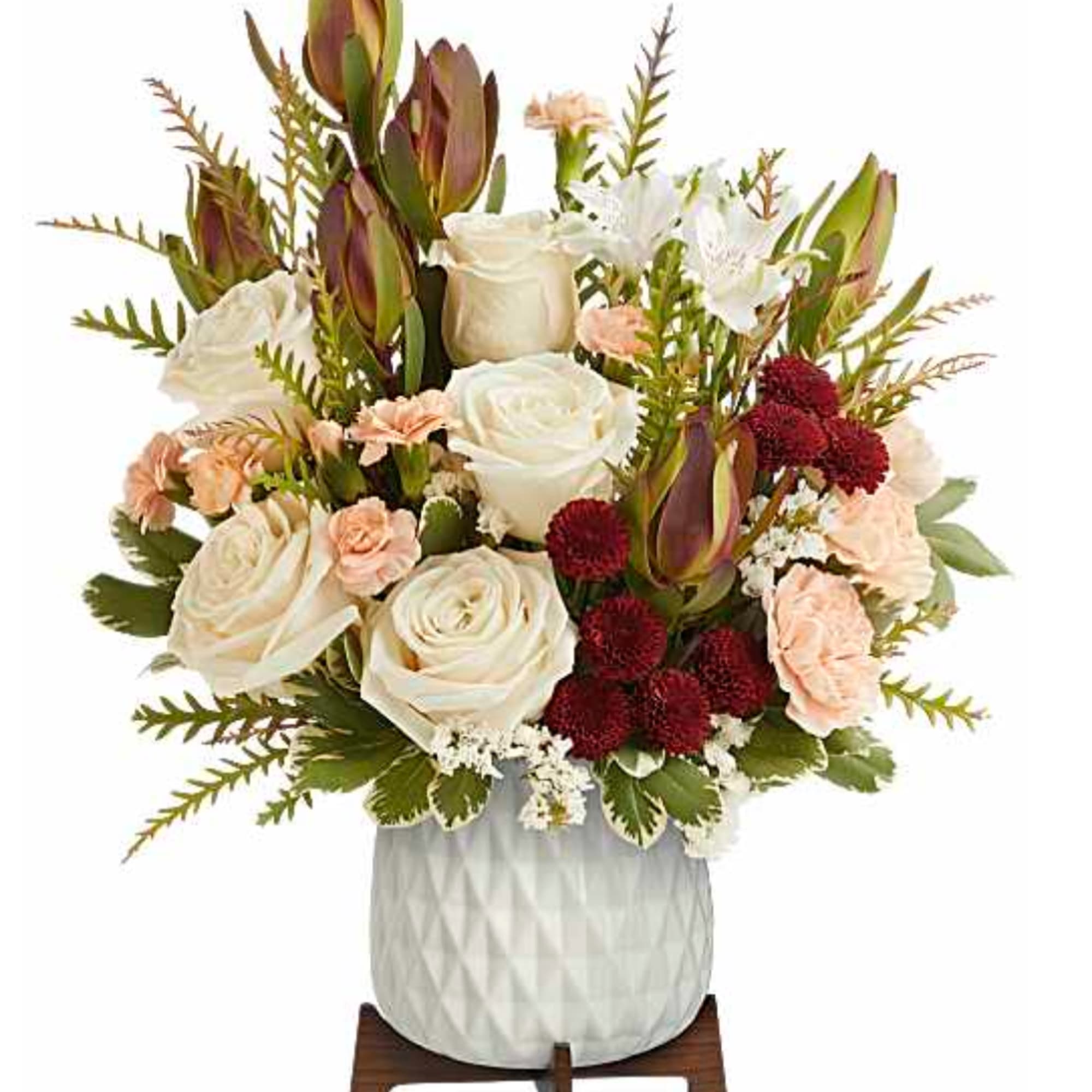 White roses and peach carnations in a white textured vase