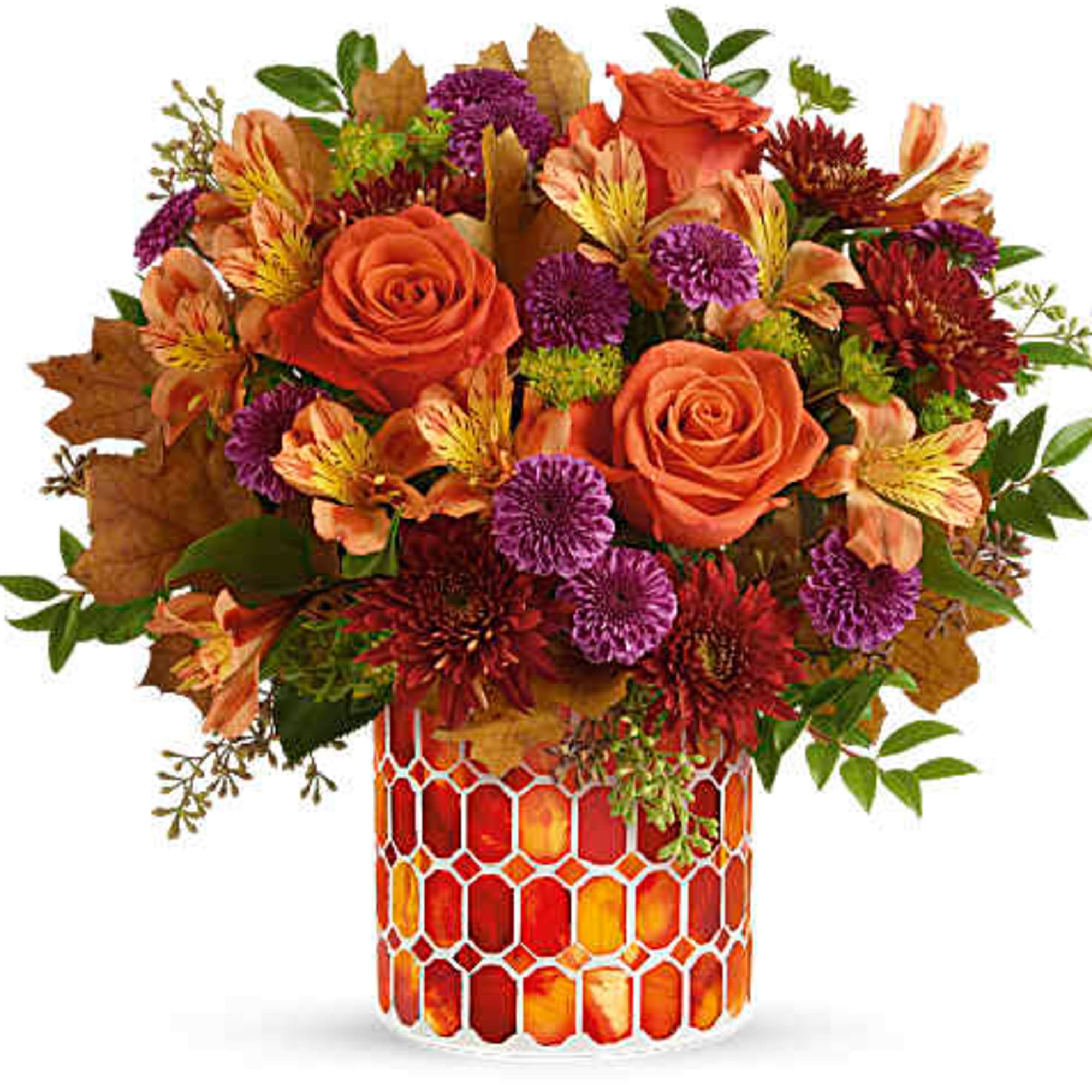 Orange roses and mixed fall flowers in a patterned glass vase