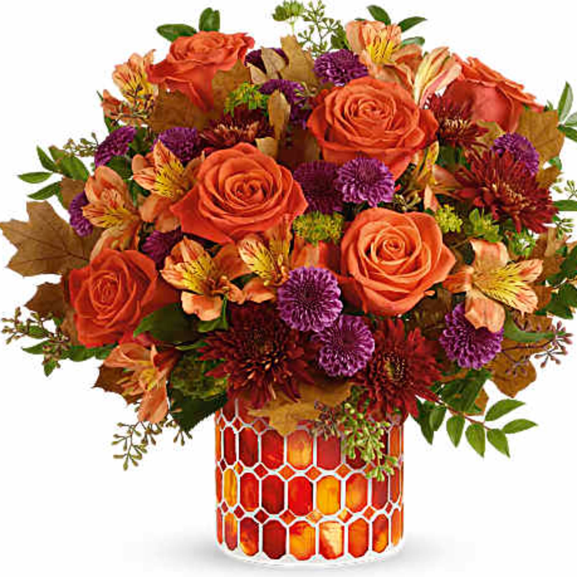 Orange roses and purple flowers in a patterned glass vase