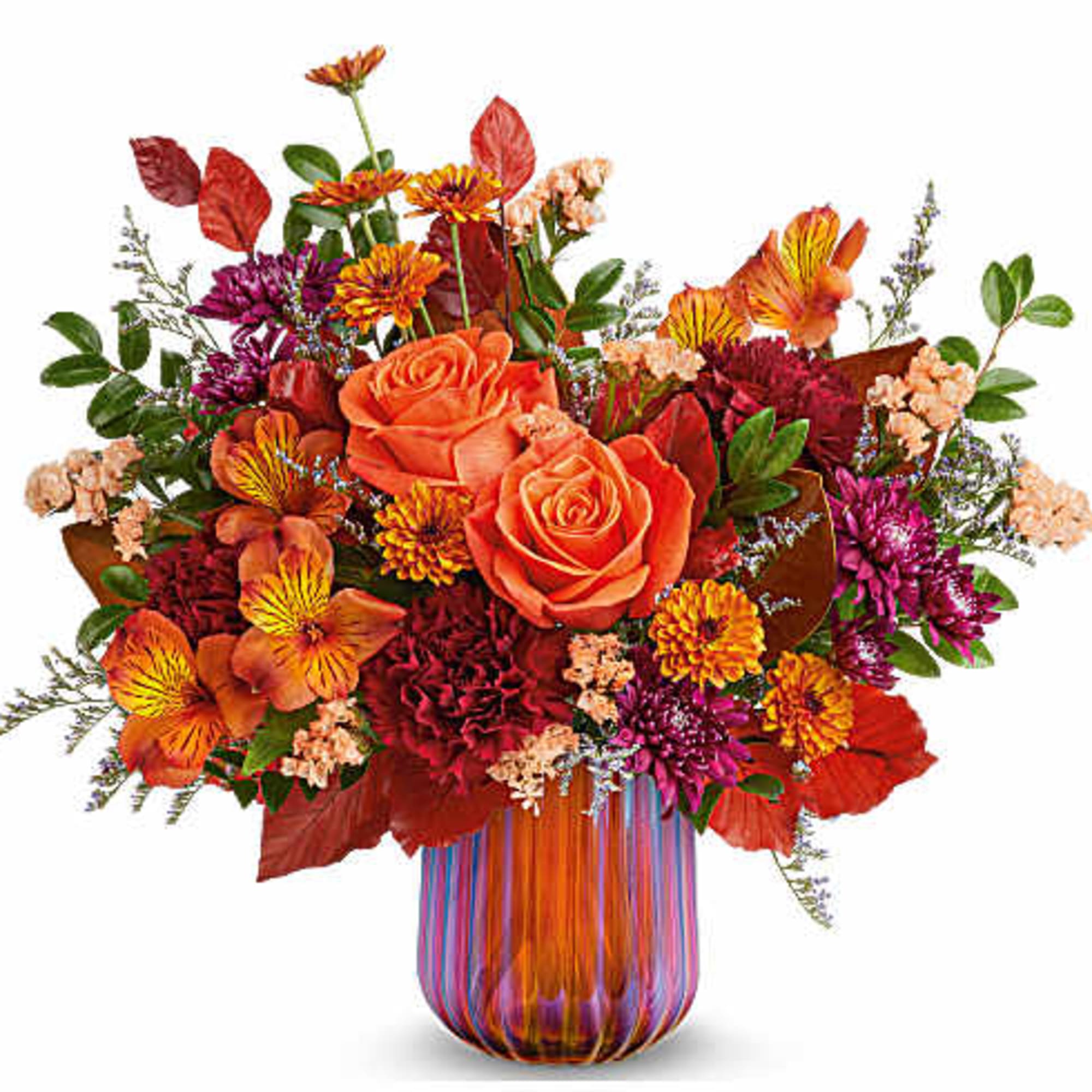 Orange roses and mixed fall flowers in a striped glass vase