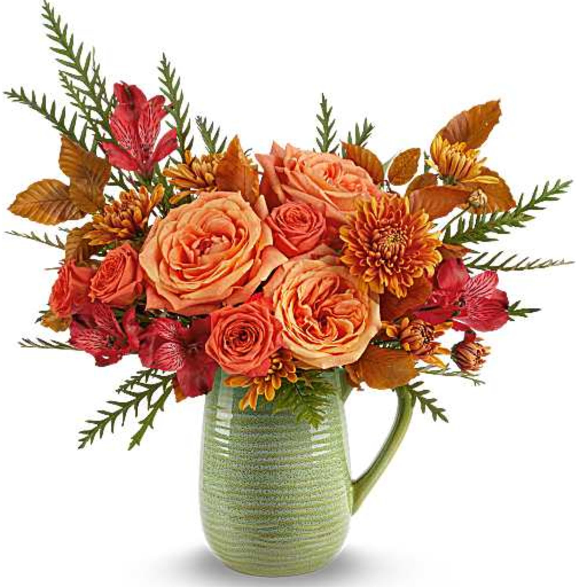 Orange and red floral arrangement in a green ceramic pitcher vase