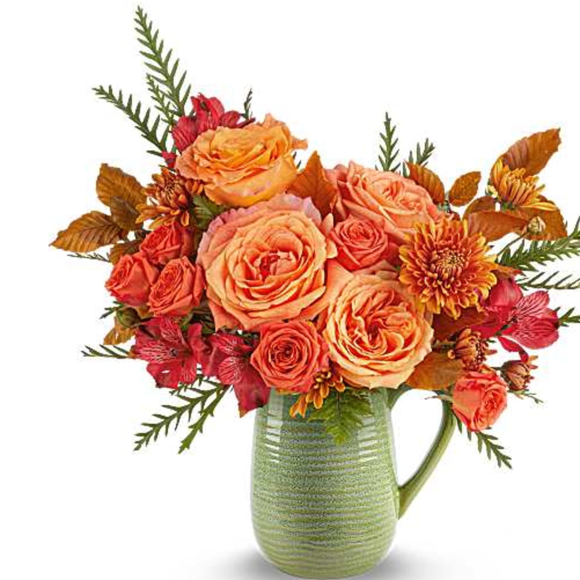 Orange and coral roses in a green ceramic pitcher vase