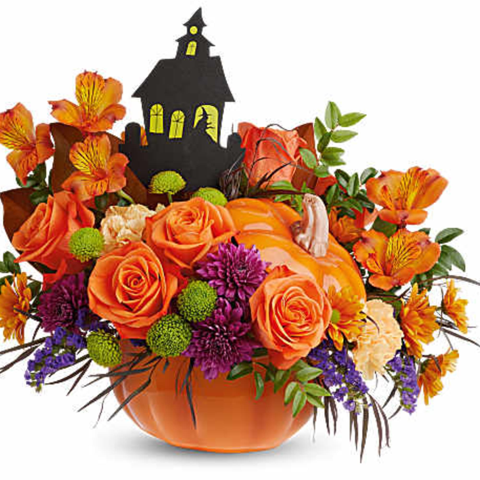 Orange roses and mixed fall flowers in a pumpkin vase with a haunted house pick