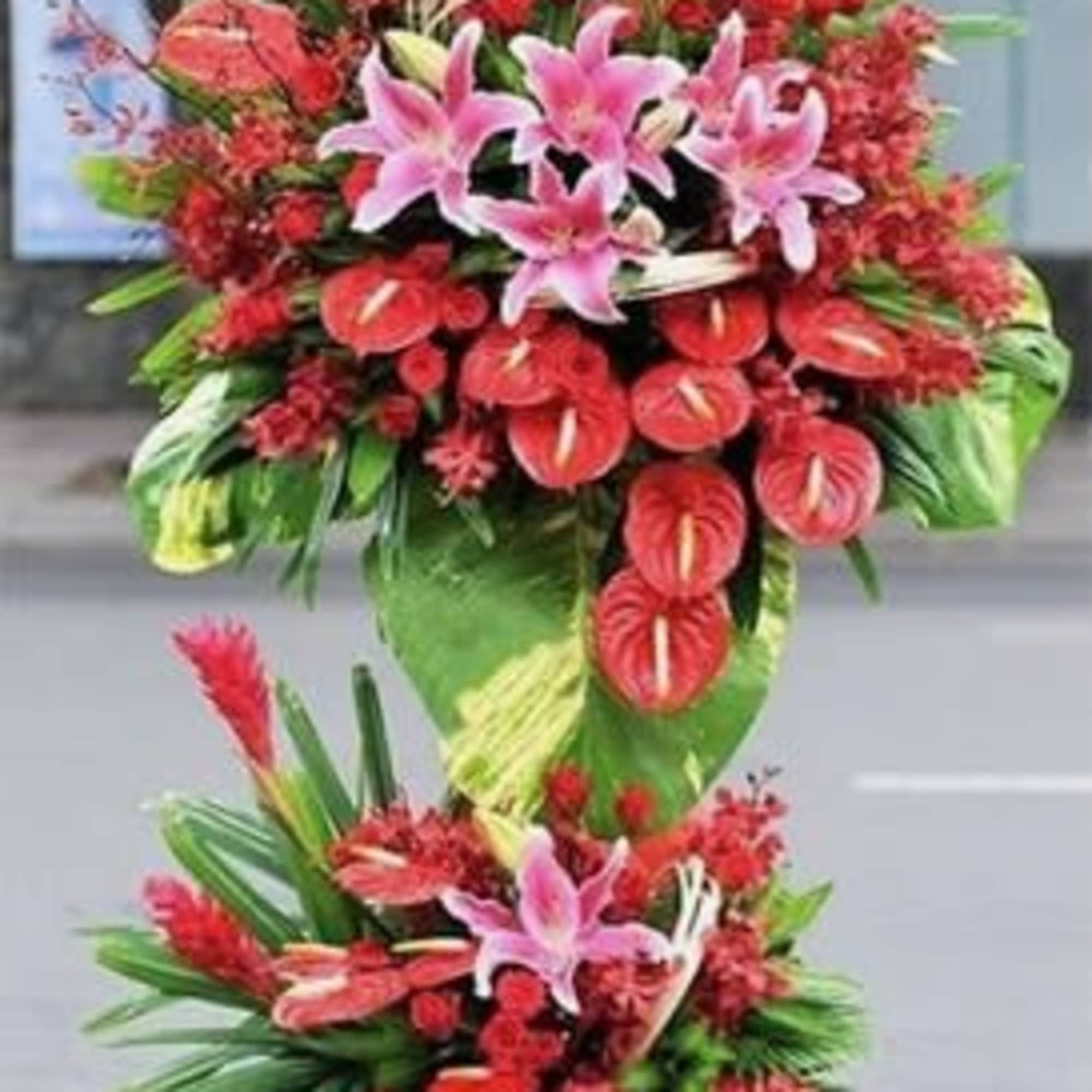 Tall tropical flower stand with pink lilies and red anthuriums