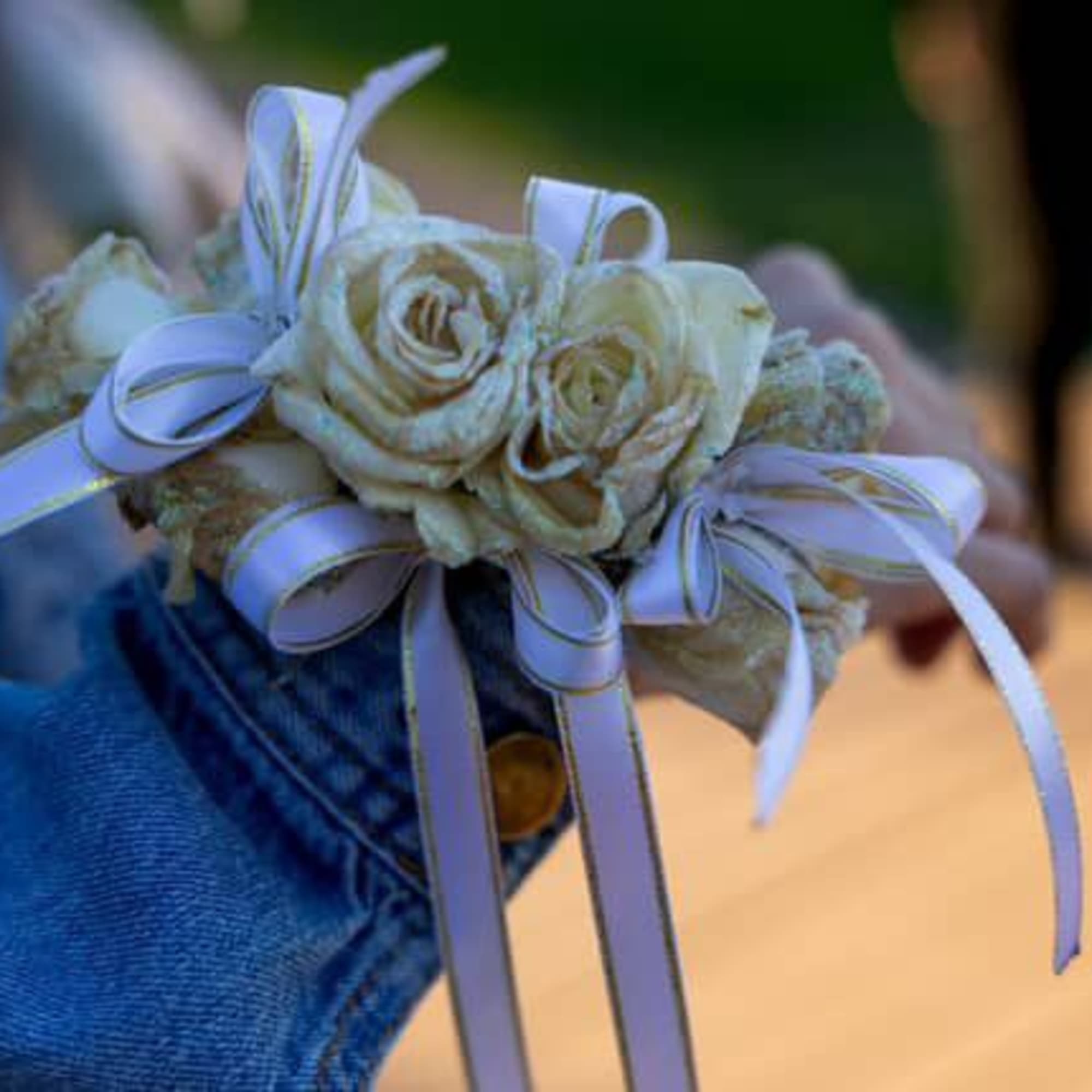 Small wrist corsage with cream roses and lavender ribbons