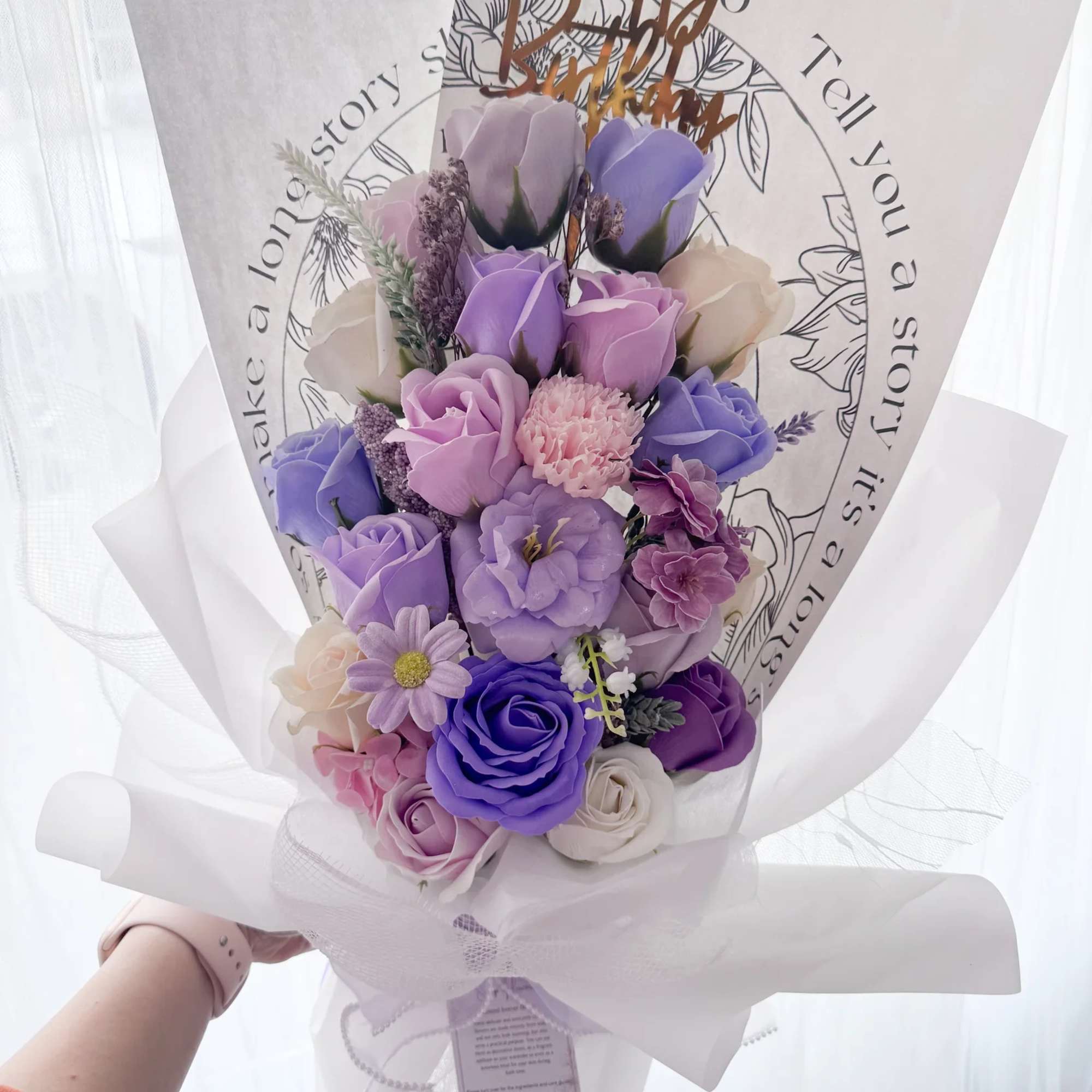 Bouquet of purple and pink roses wrapped in white paper