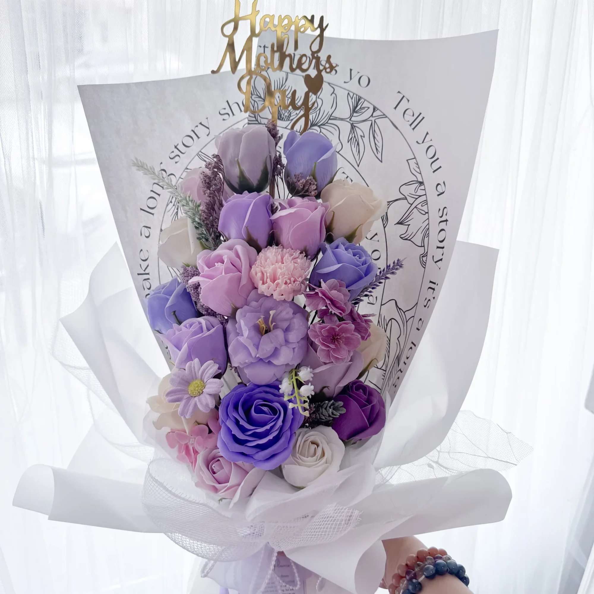 Lavender and purple bouquet with roses and mixed blooms wrapped in white paper