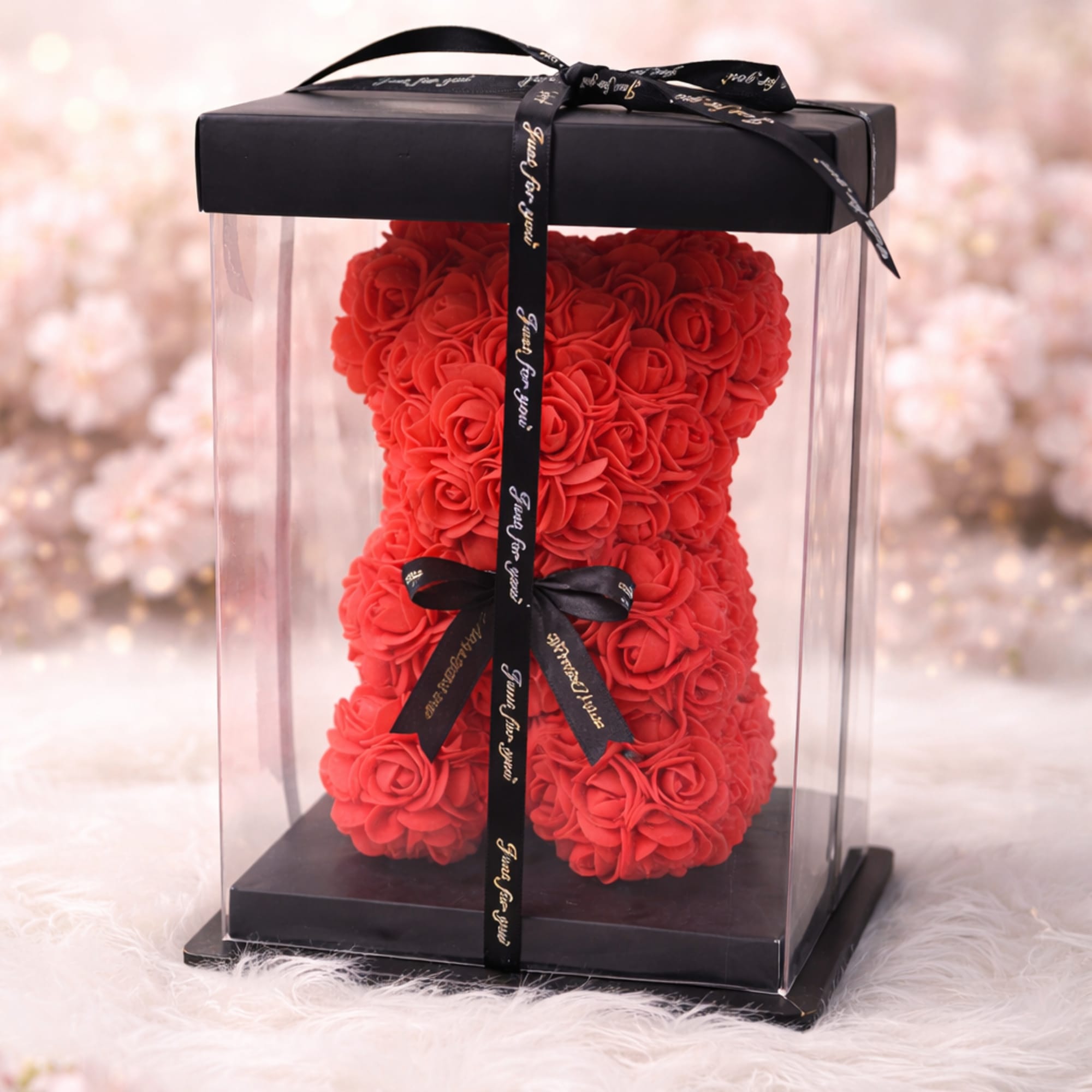 Red rose teddy bear in a clear gift box with a black ribbon