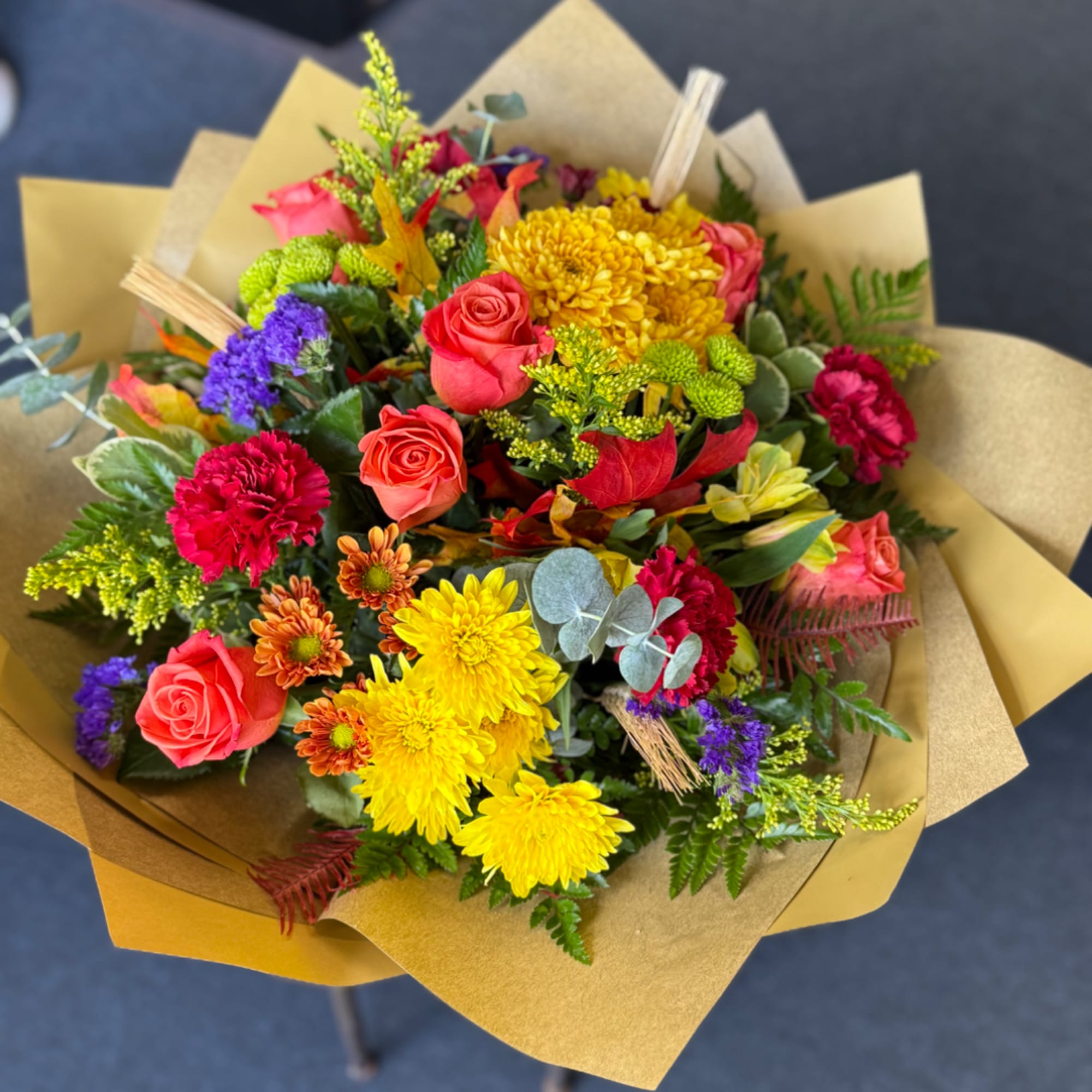 Mixed bouquet of roses, chrysanthemums, and carnations wrapped in kraft paper, photo 2 of 2