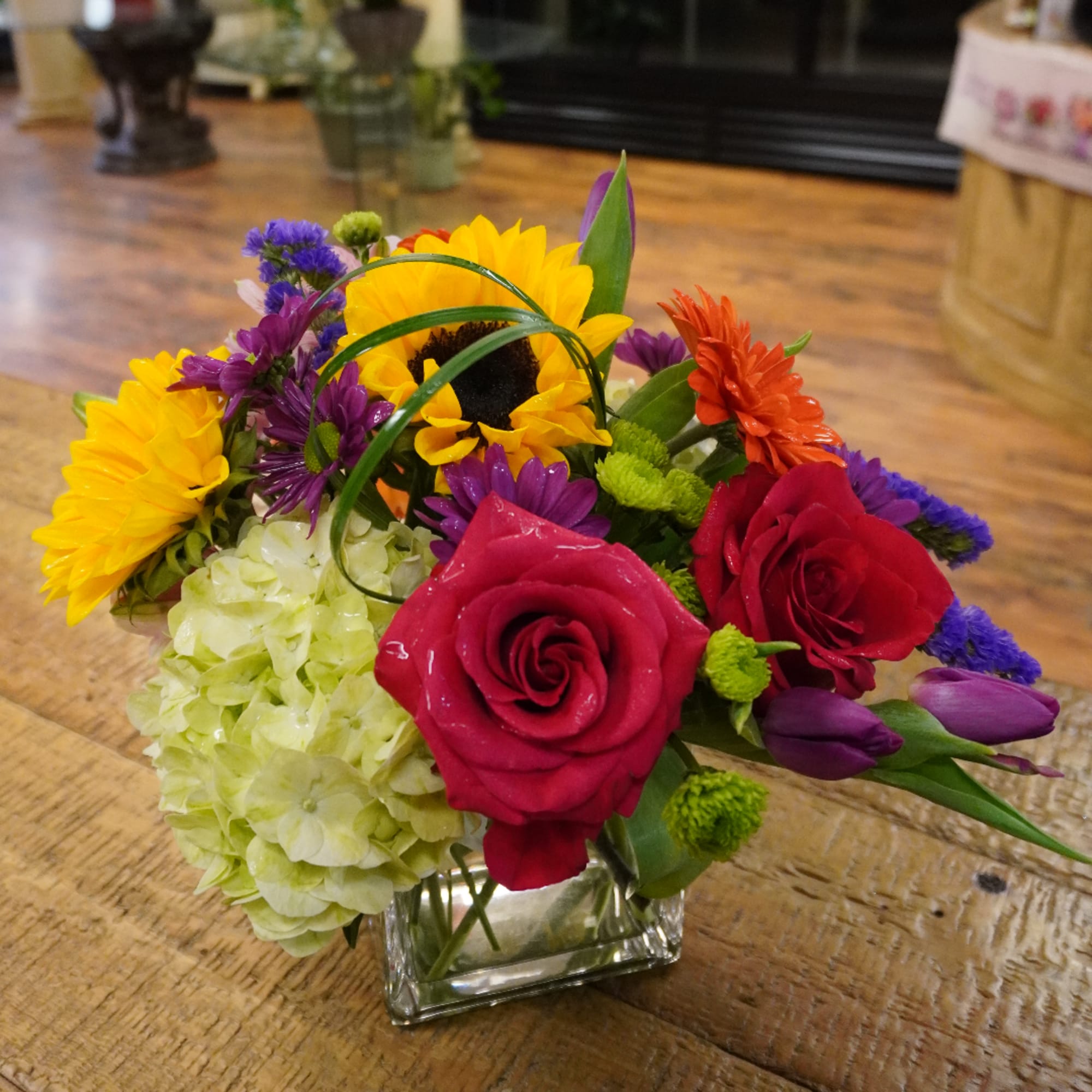 Colorful mixed flower arrangement in a square glass vase