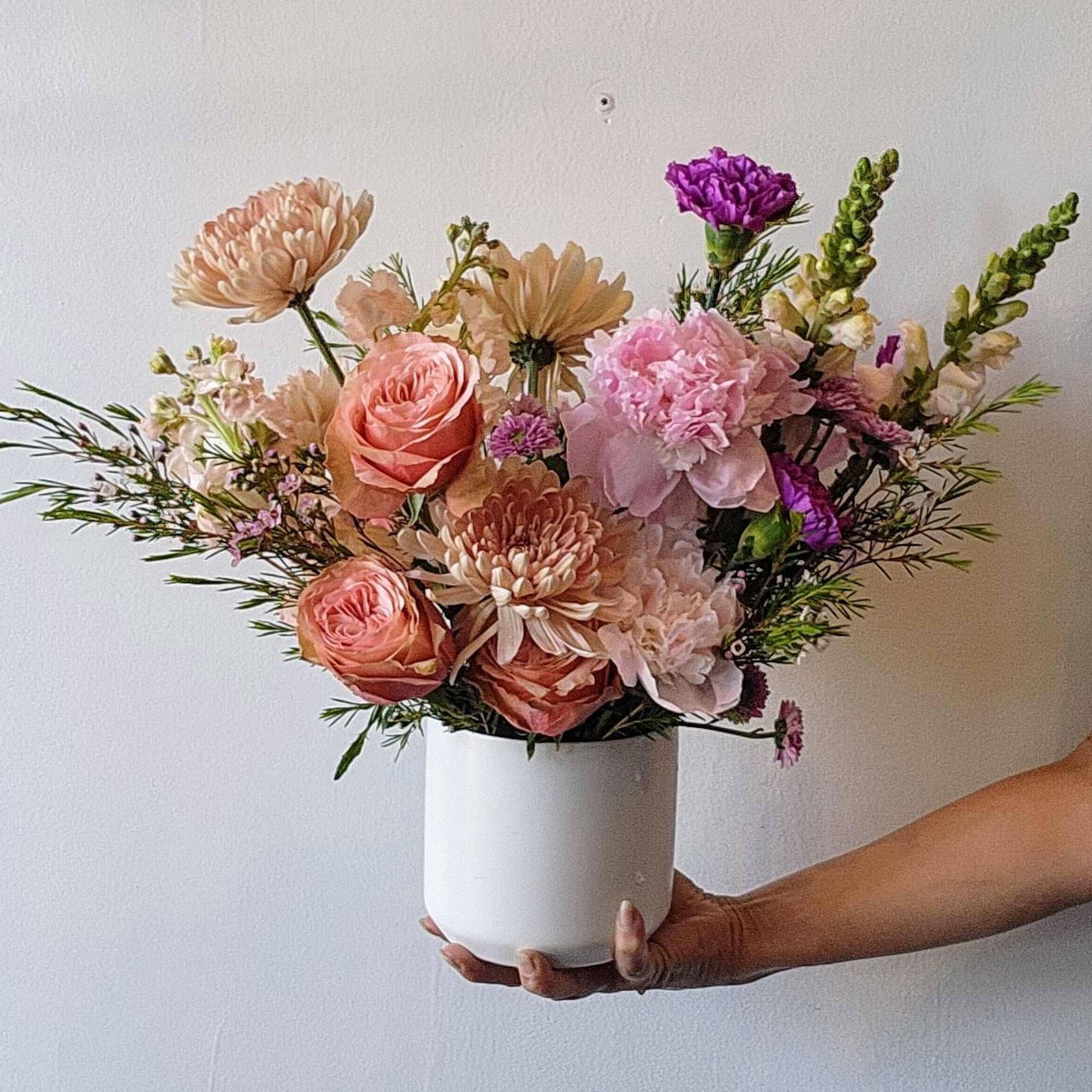 An abundant, garden-style arrangement designed with lush layers of soft spring blooms