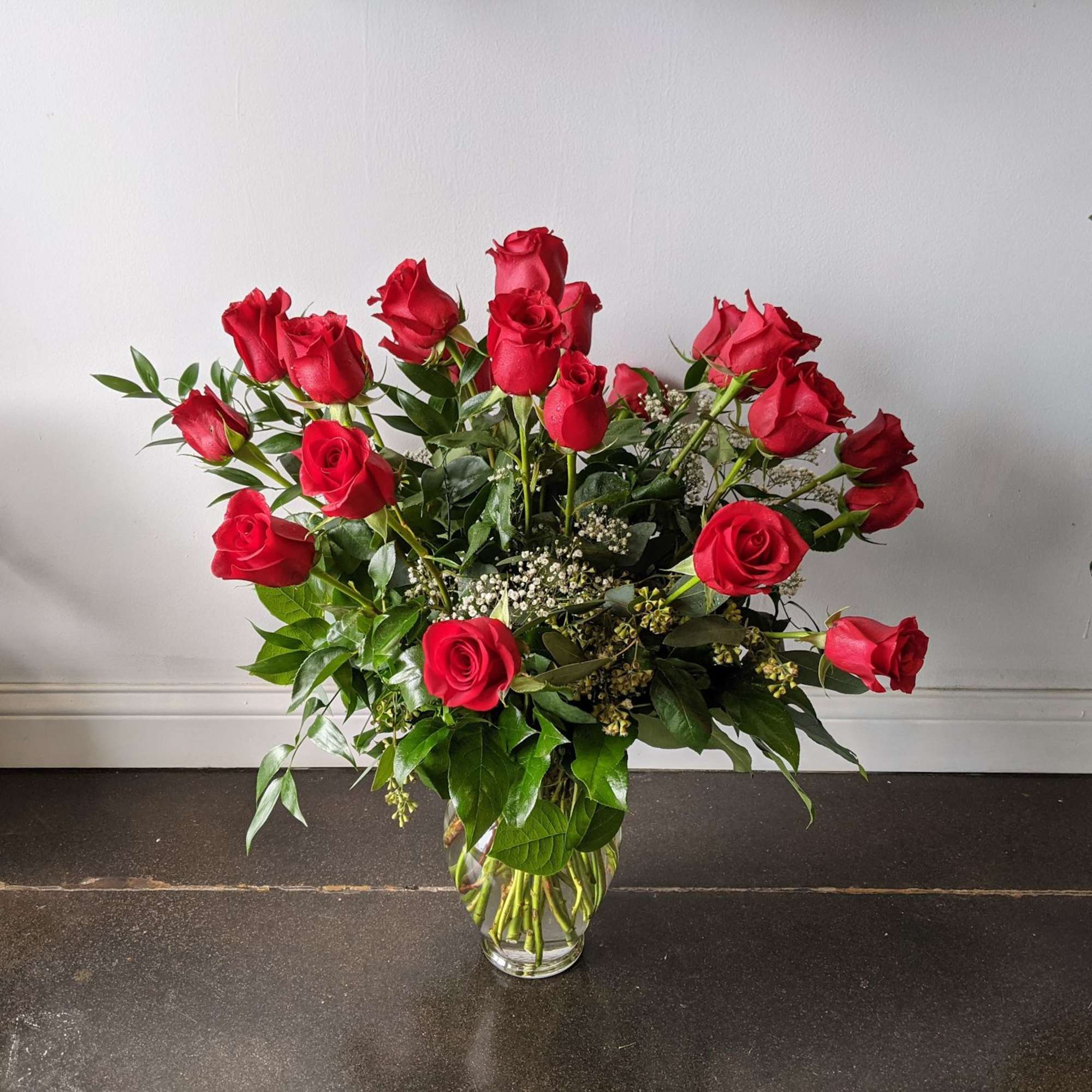 Red roses arranged in a clear glass vase